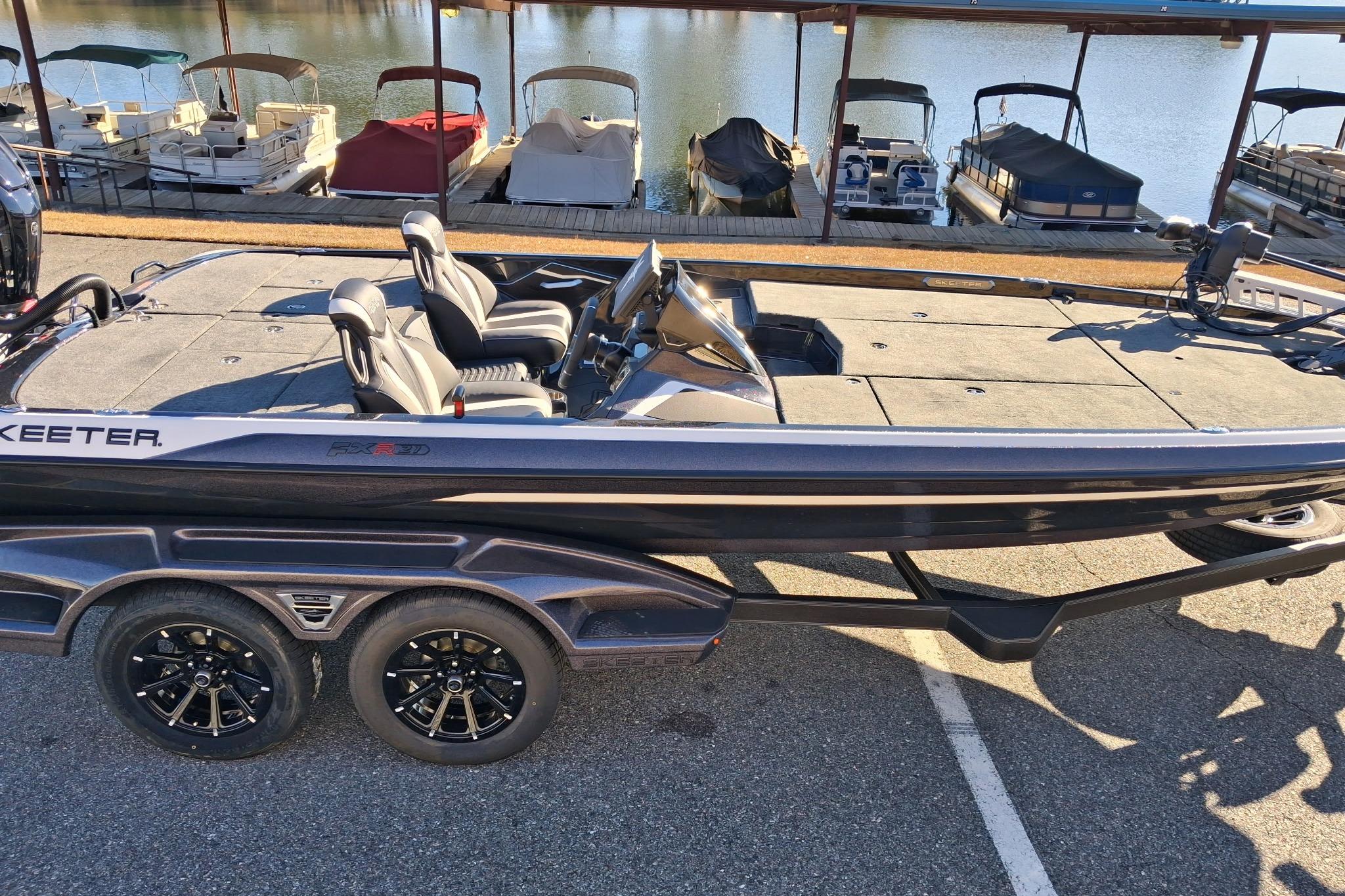2026 Skeeter FXR21 FLEX boat on trailer by a marina, showcasing sleek design and modern features.