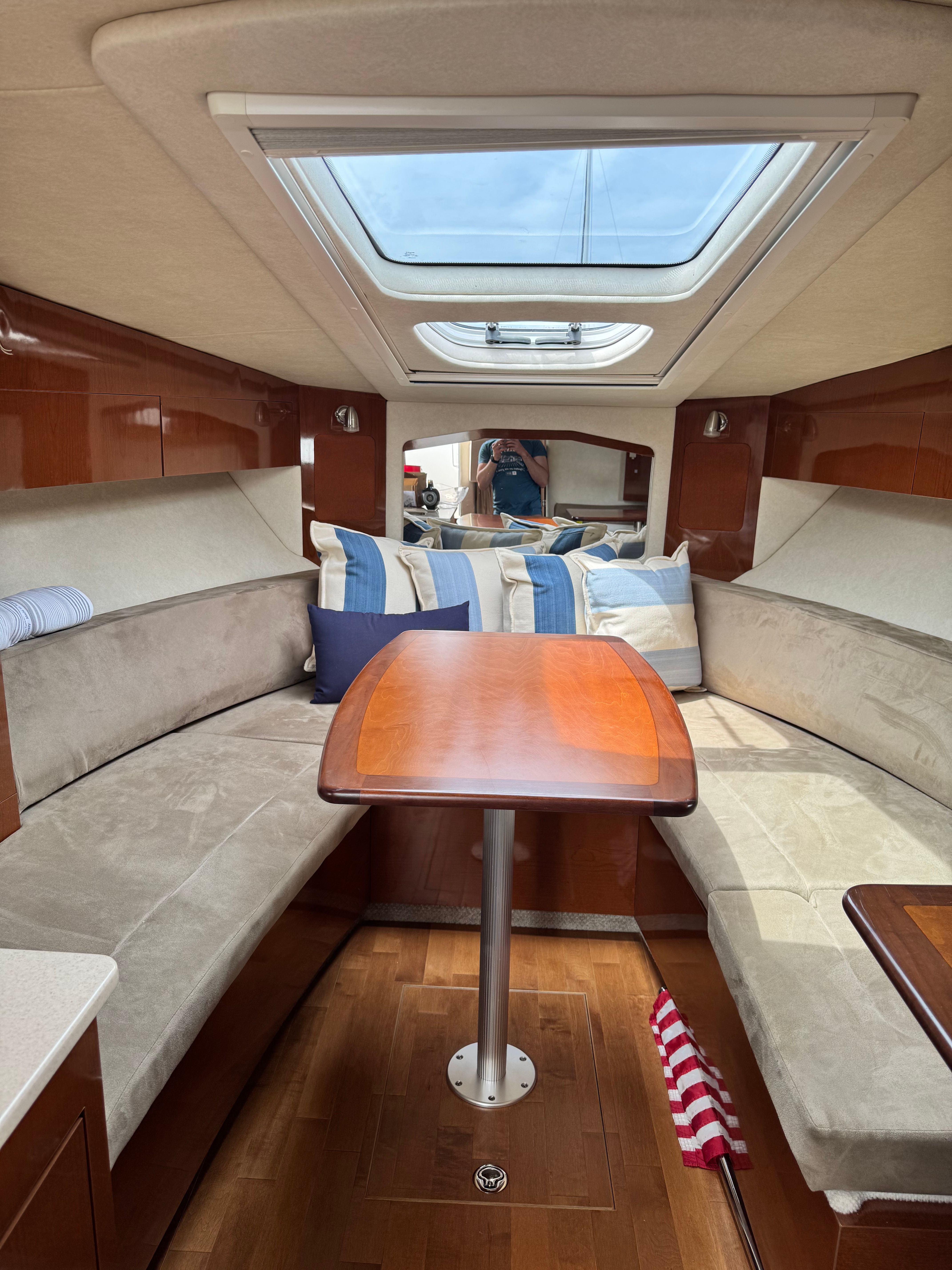 Interior of a Sea Ray Sundancer 310 with cozy seating and a wooden table.