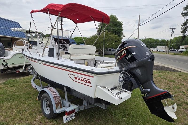 1996 Boston Whaler Outrage 17 boat with red canopy and Yamaha outboard motor on trailer.