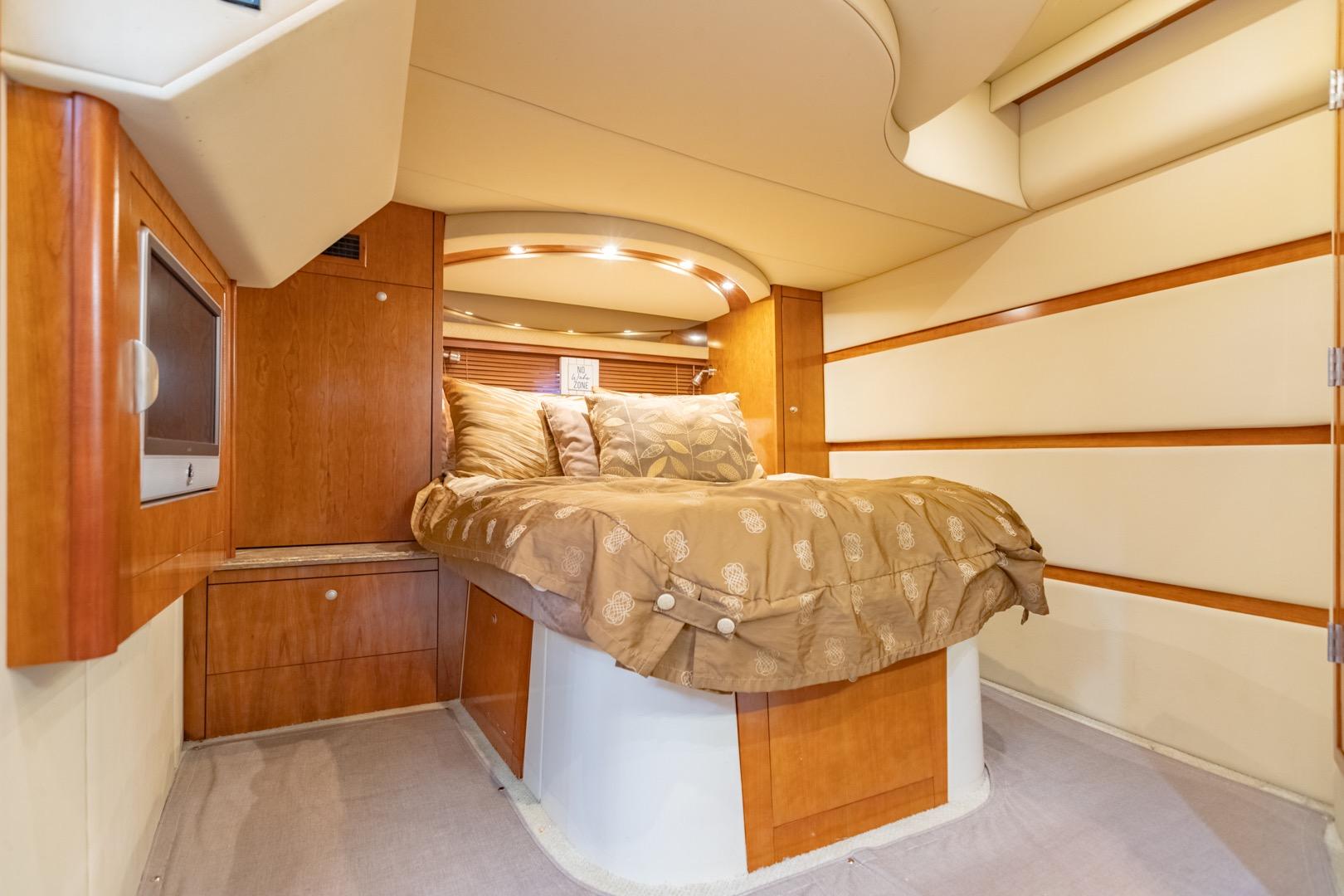 Luxurious cabin interior of 2008 Cruisers Yachts 460 Express with cozy bed and wood accents.