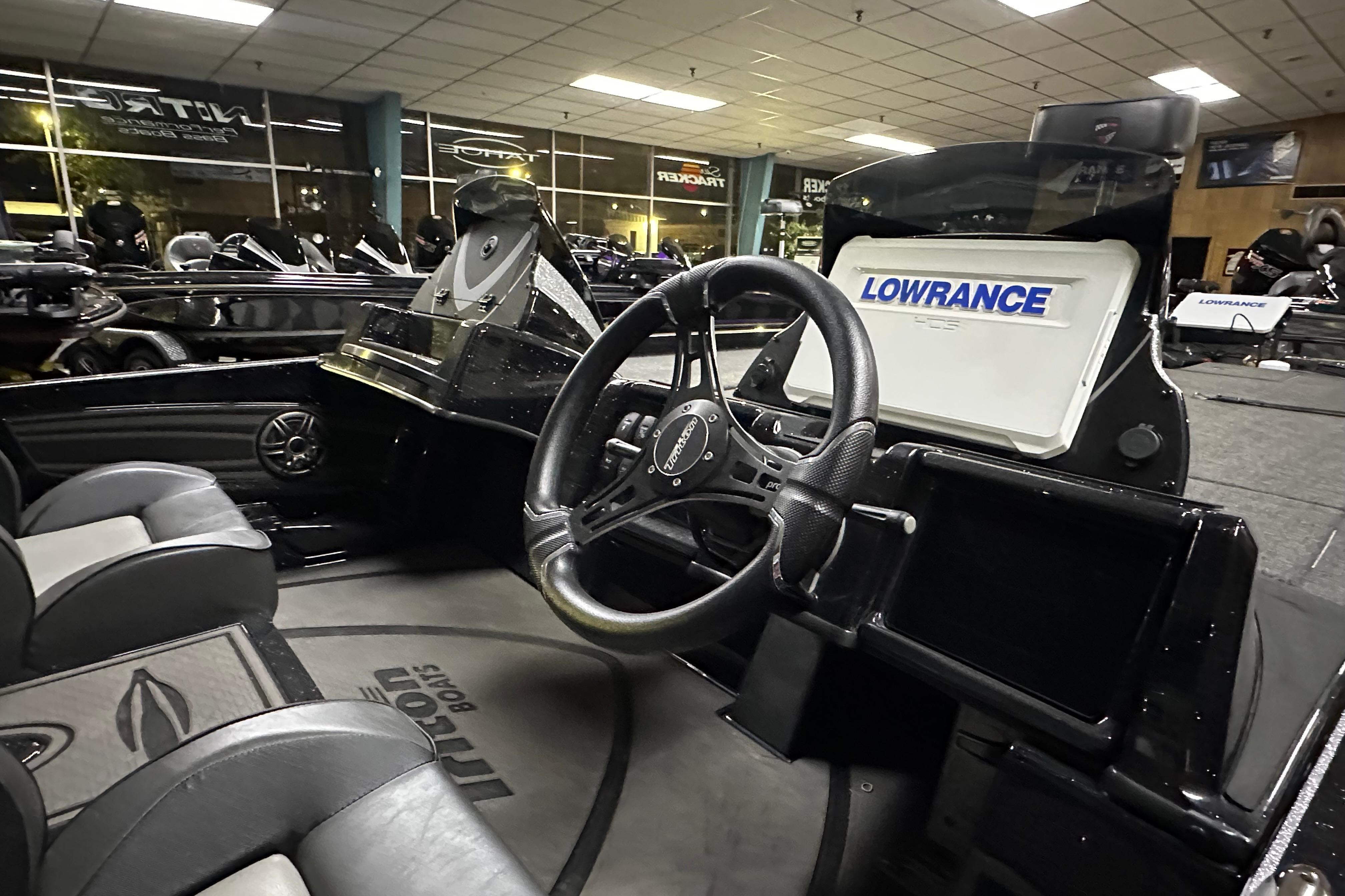 Interior of 2025 Triton 21XP Patriot boat with steering wheel and Lowrance display.