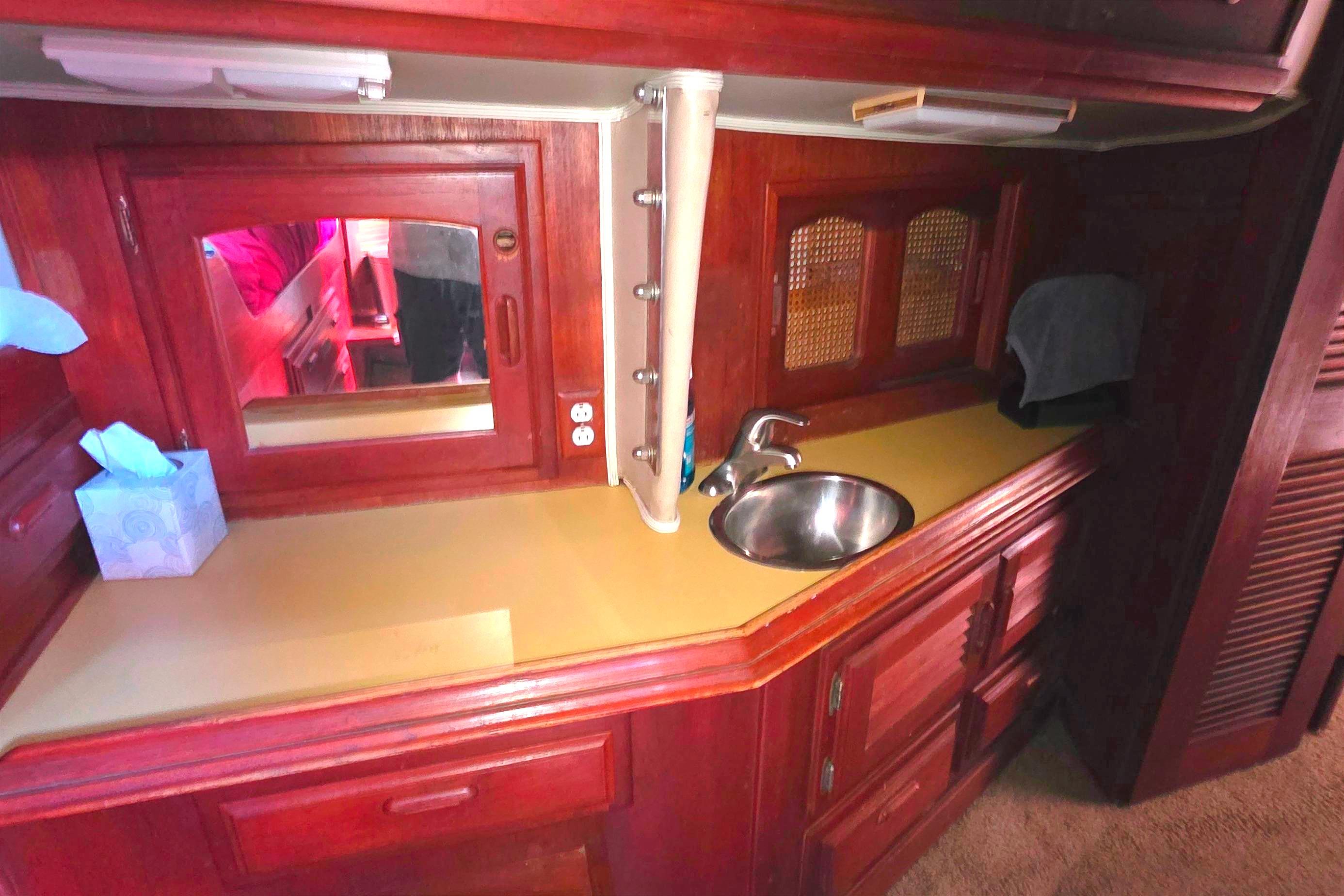 Interior of 1978 Islander Freeport 41 yacht with wooden cabinetry and compact sink area.