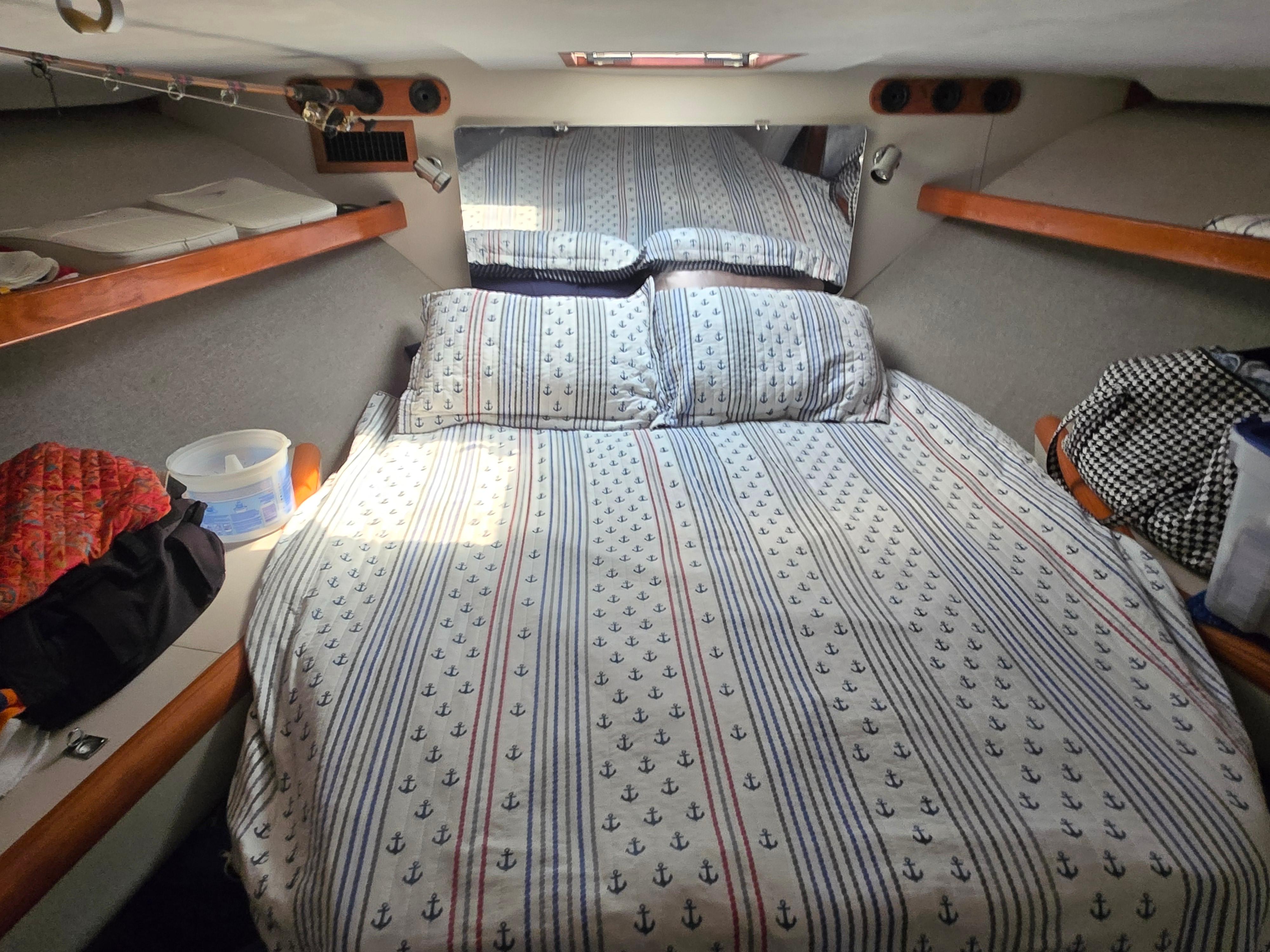 Cozy cabin interior of 1992 Luhrs Tournament 320 Convertible with nautical-themed bedding.