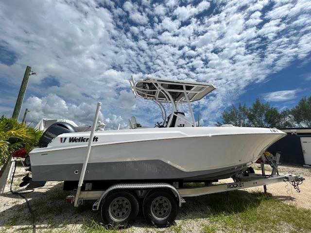 2022 Wellcraft 222 Fisherman boat on trailer under cloudy sky.
