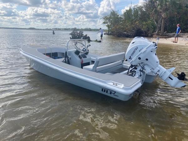 2024 Ultra Lite Tenders ULT 380 boat in shallow water, featuring a white exterior and outboard motor.