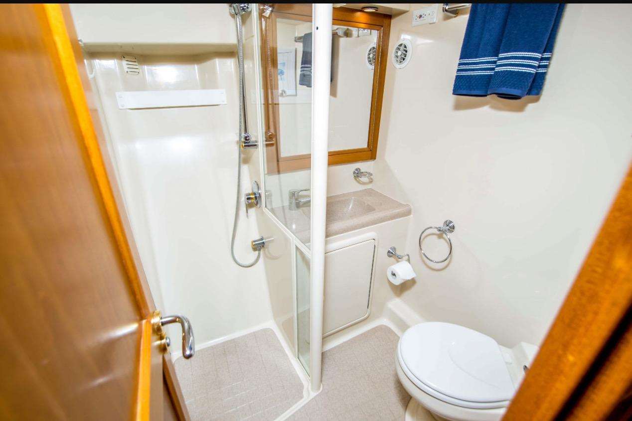 Bathroom interior of 2000 Riviera 48 Enclosed Flybridge yacht, featuring shower and toilet.