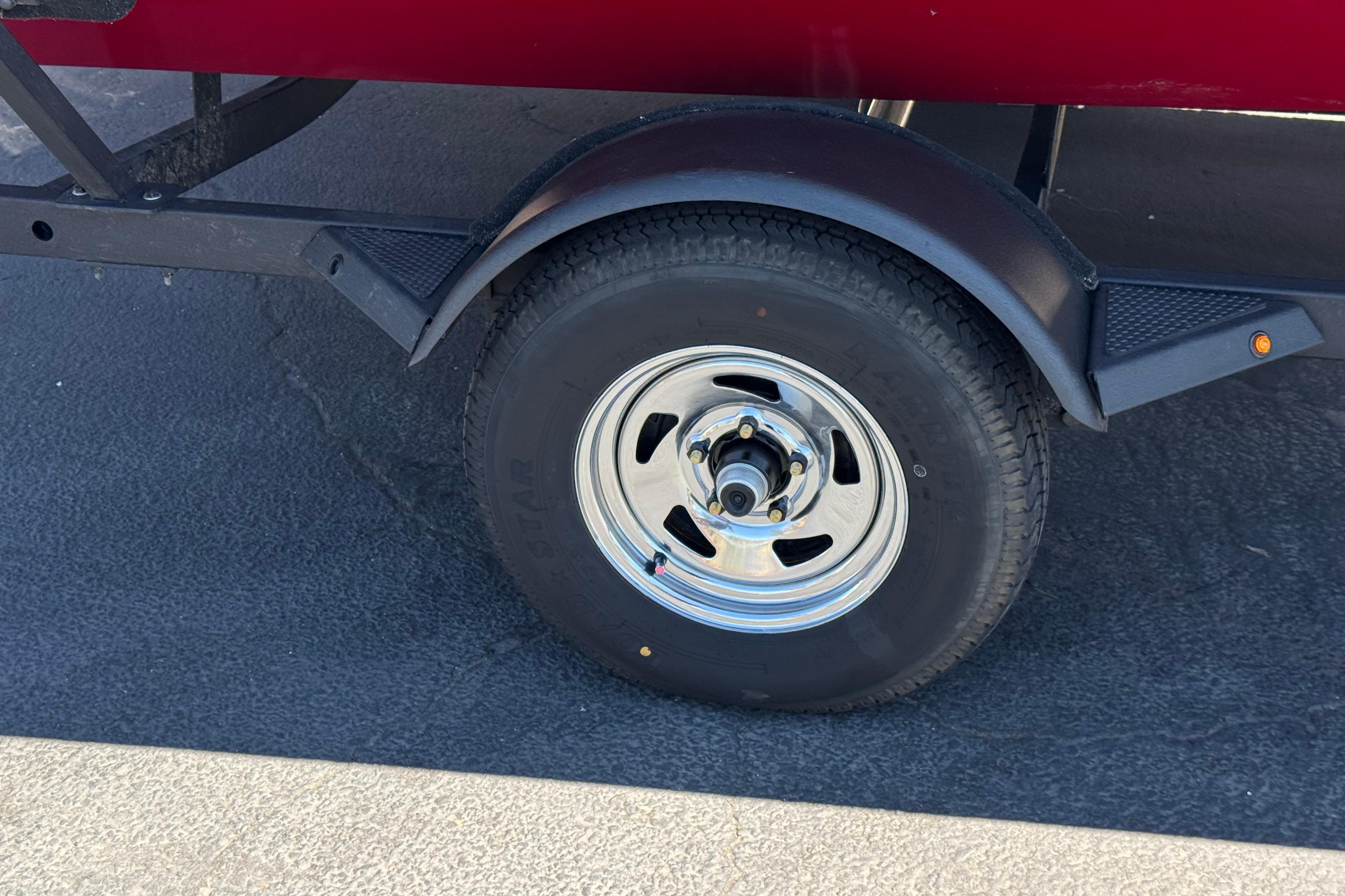 Trailer wheel of 2025 Tracker Pro Team 175 TXW boat on asphalt.
