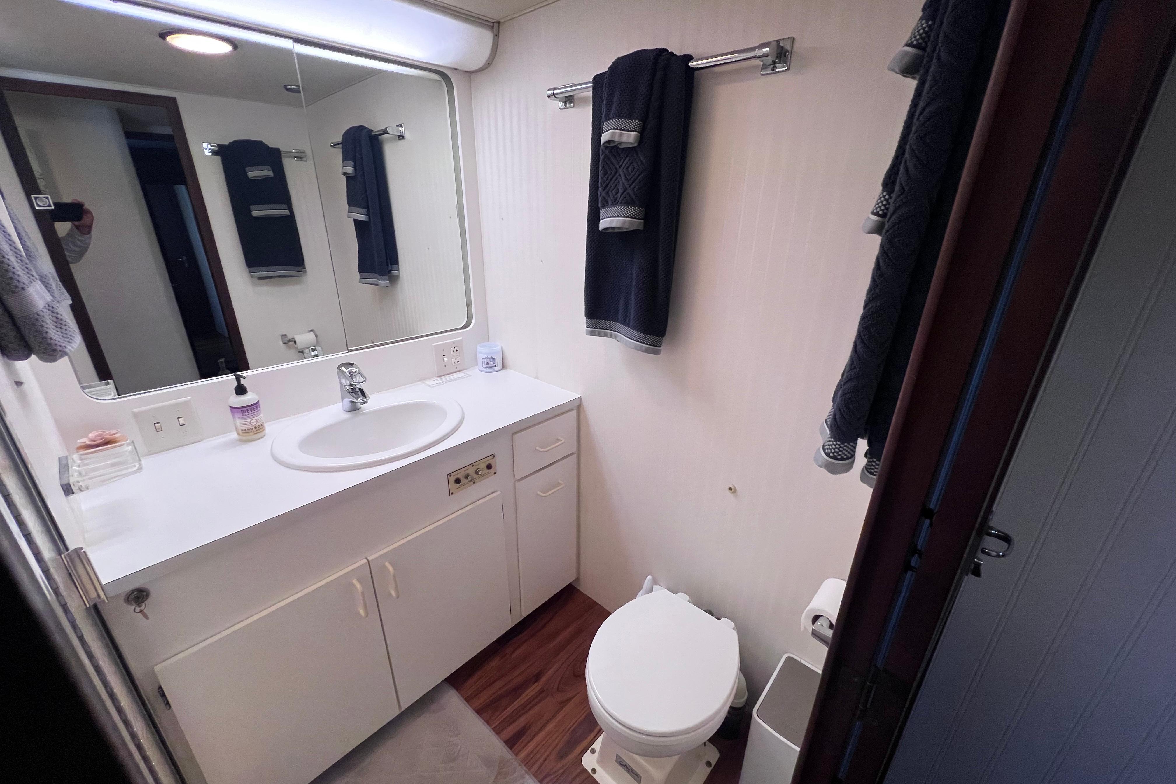 Bathroom interior of 1987 Hatteras 70 Cockpit Motor Yacht, featuring sink and toilet.