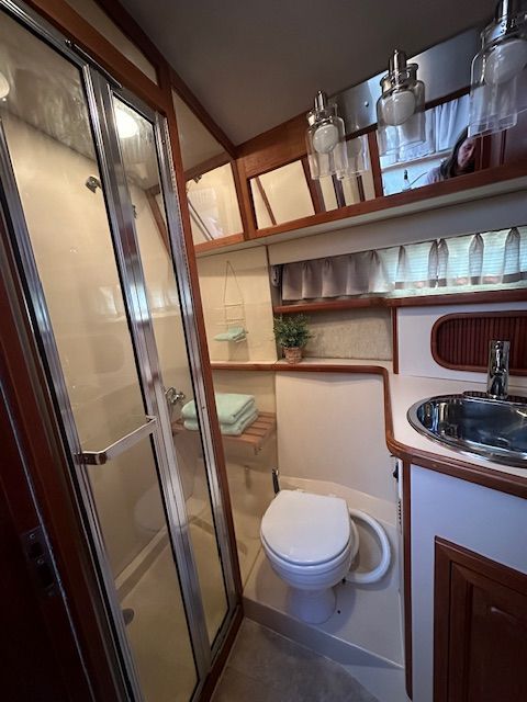 1988 Carver 3807 Aft Cabin Yacht bathroom with shower and sink.