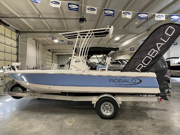 2025 Robalo 206 Cayman boat in showroom, side view with blue and white design.