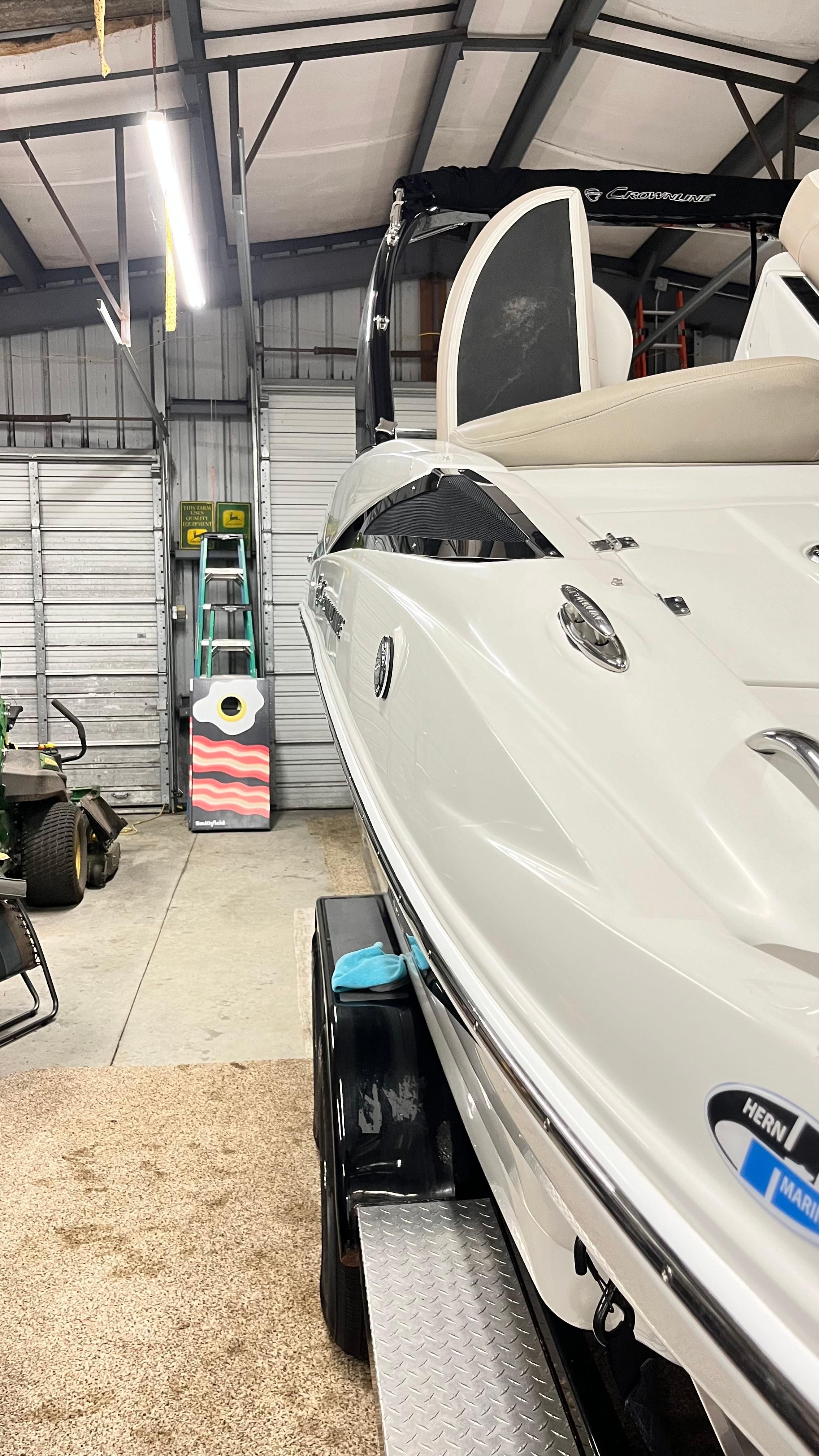 2019 Crownline E 285 in a garage, featuring a sleek white hull and modern details.