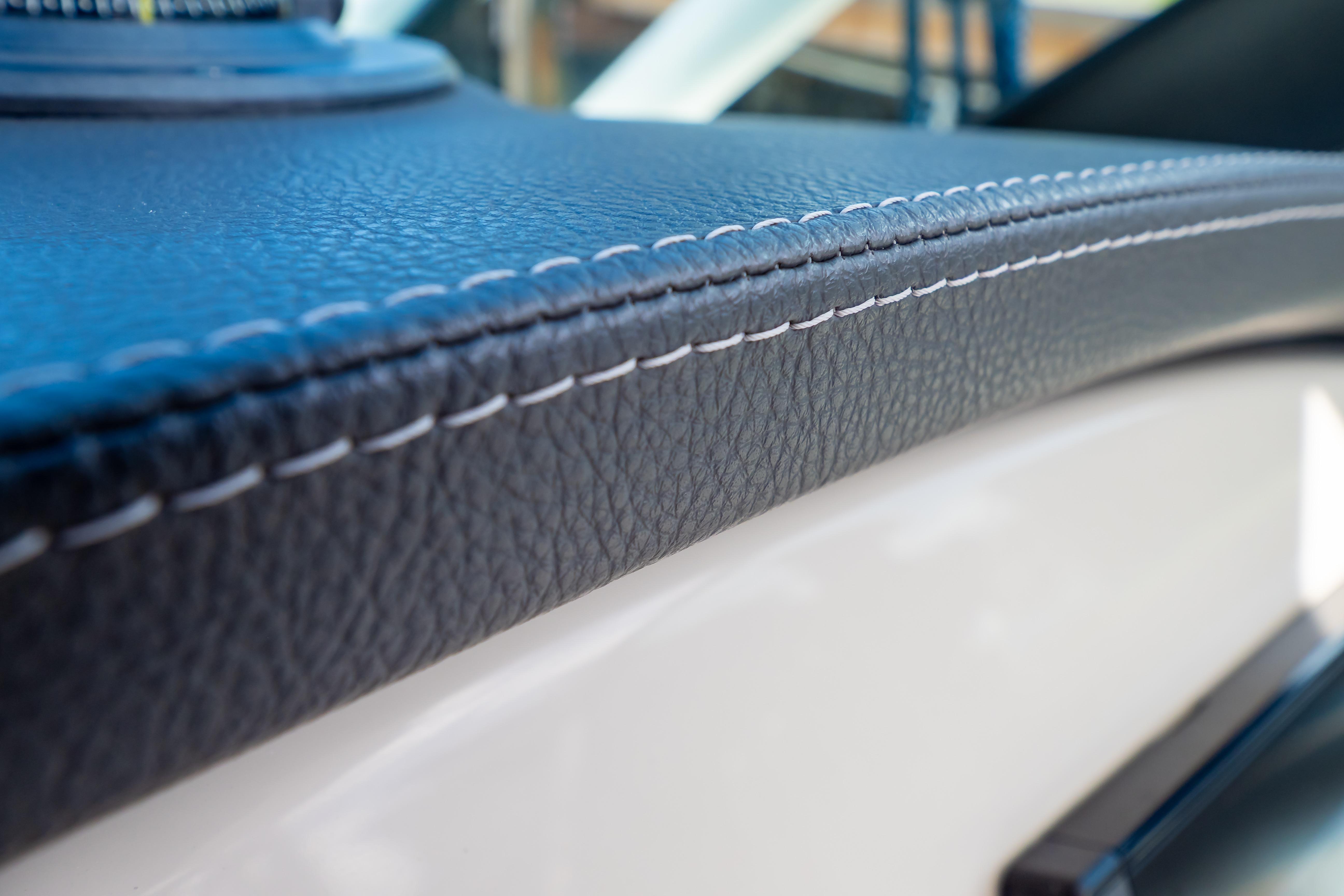 Close-up of 2019 Boston Whaler 270 Vantage's detailed leather stitching on dashboard.