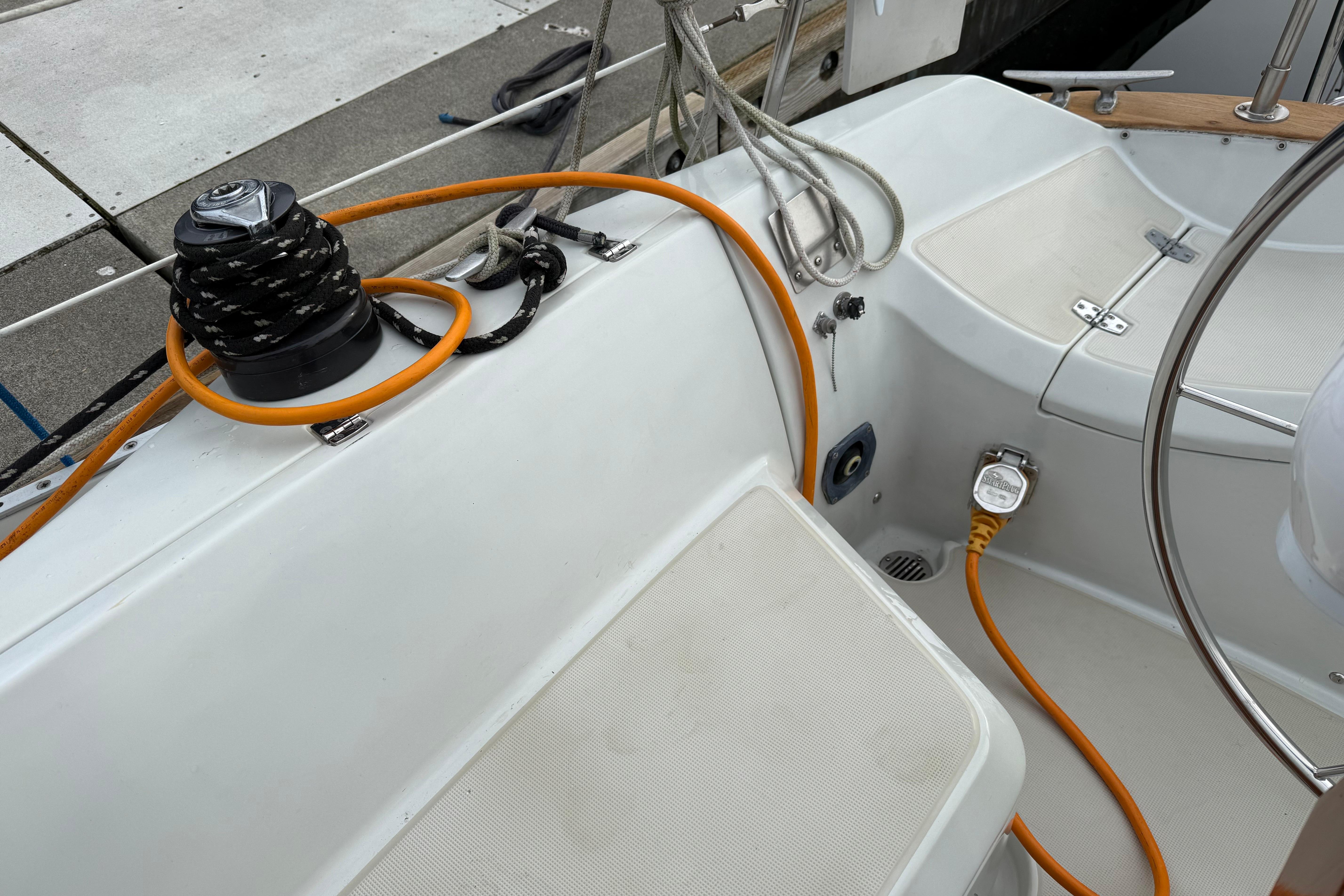 Cockpit of 1988 Ericson 32-200 sailboat with winch, ropes, and electrical connections.
