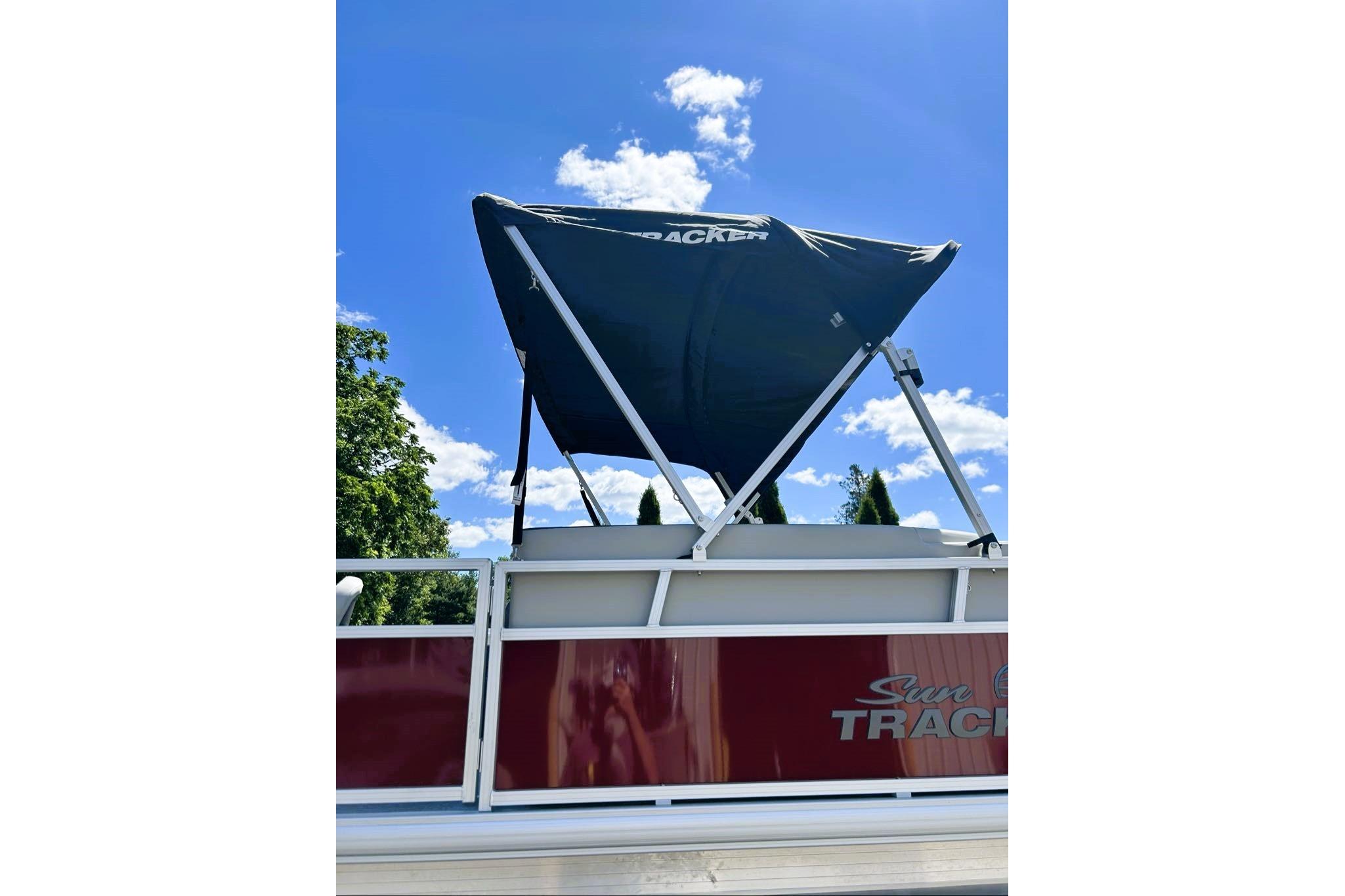 2026 Sun Tracker Bass Buggy 16 XL Select pontoon boat with canopy under blue sky.