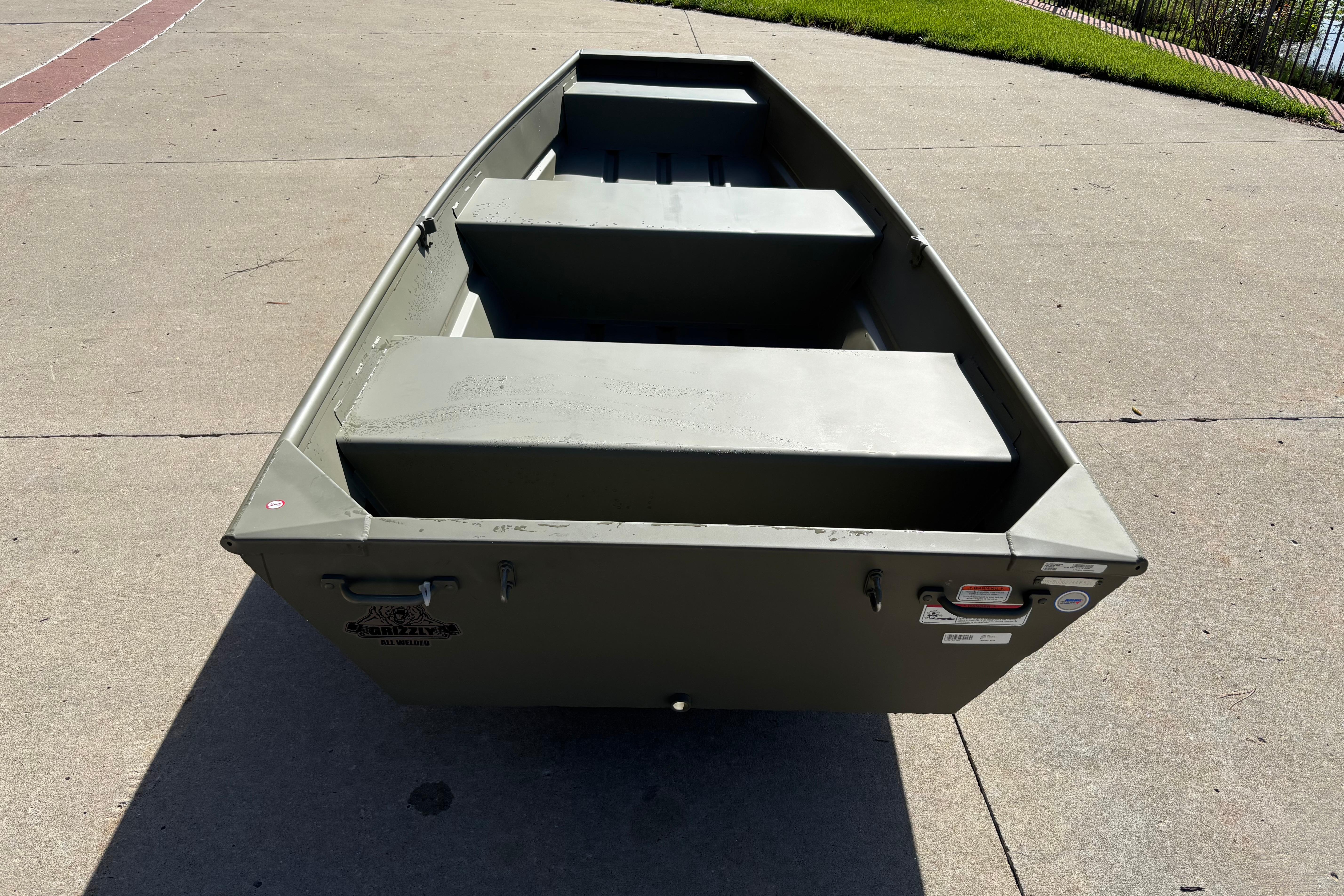 2026 Tracker Grizzly 12 Jon boat on concrete surface, showcasing its sturdy design.