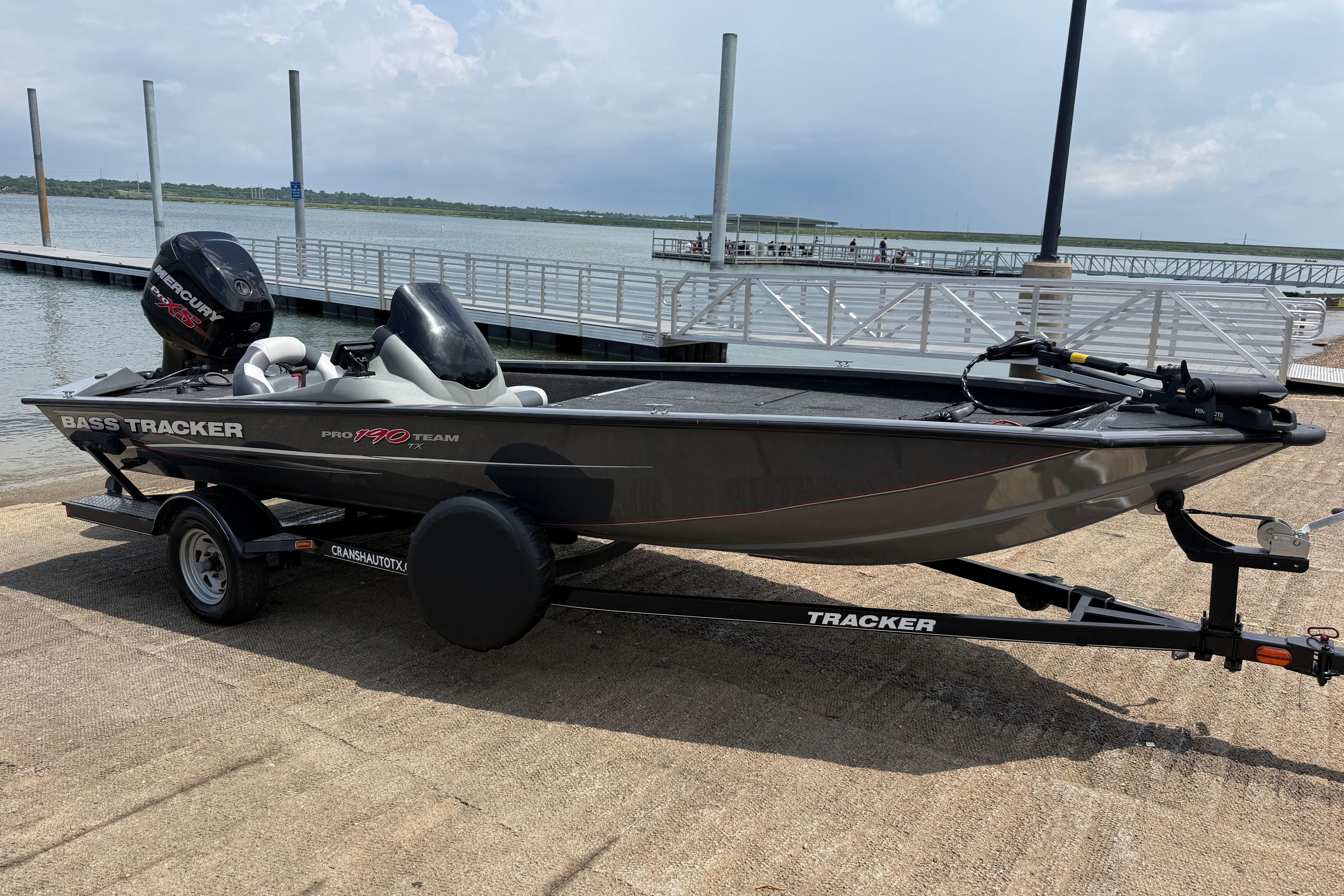 2015 Tracker Pro Team 190 TX bass boat on trailer by a lake dock.