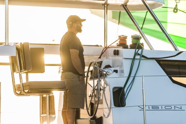 Man steering Vision 444 yacht at sunset, 2025 model.