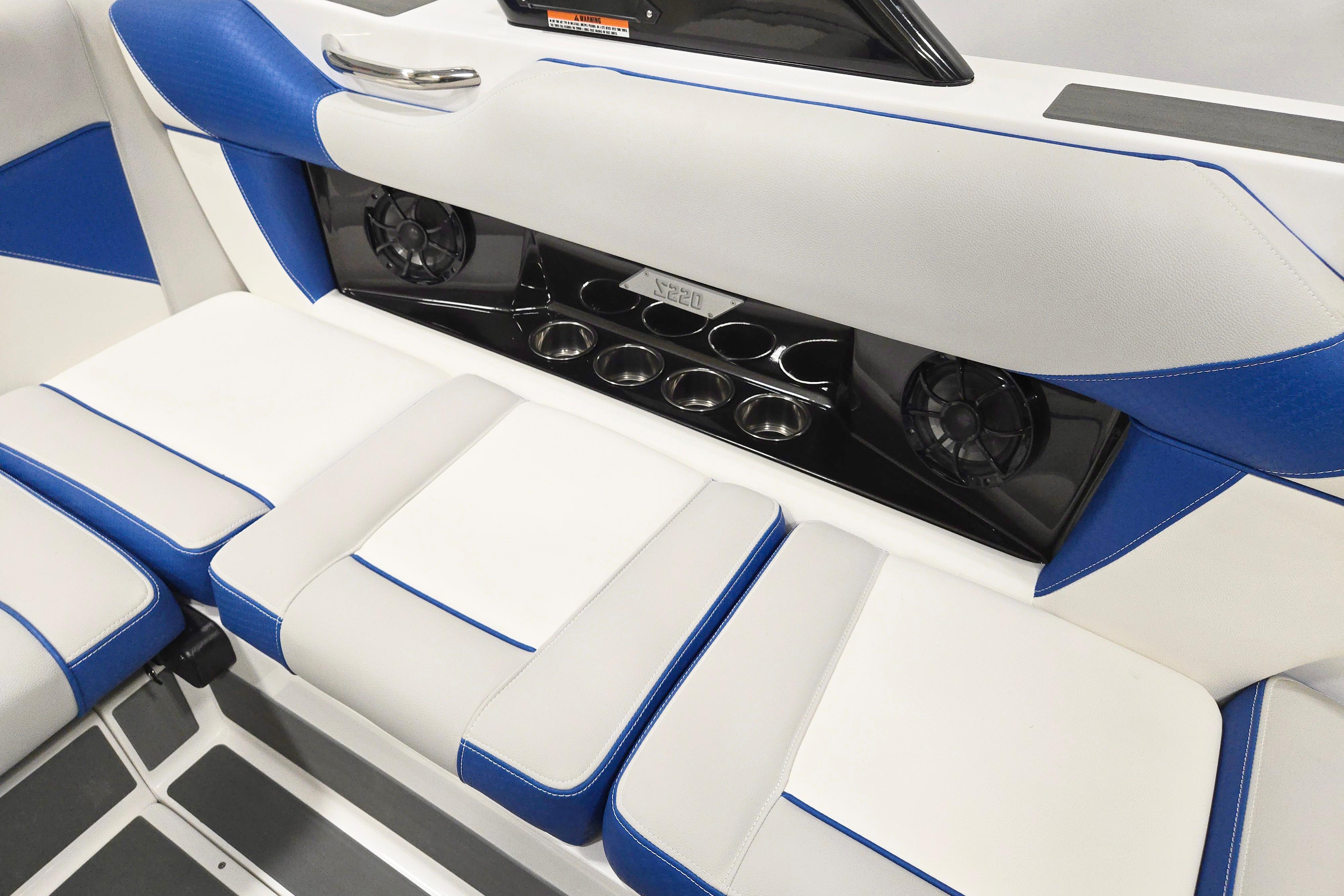 2026 Supreme S220 boat interior with blue and white seating, cup holders, and speakers.