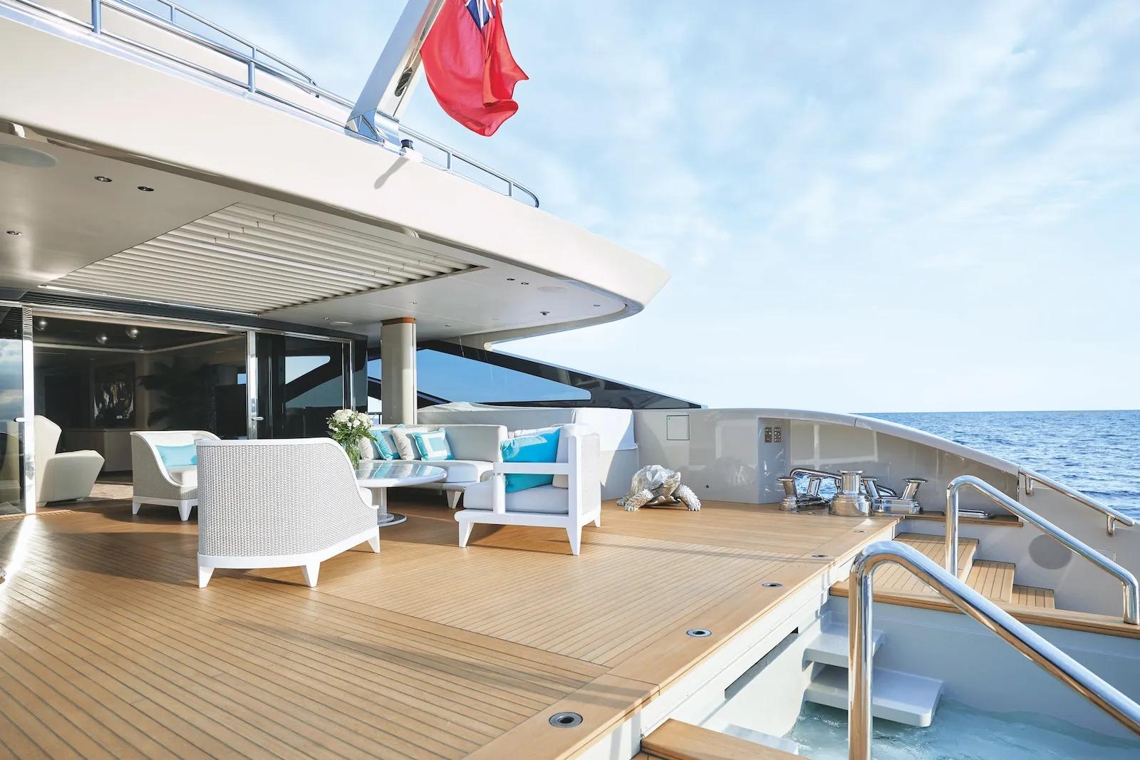 Luxurious Benetti B.NOW 50M yacht deck with elegant seating, ocean view, and flag, 2021 model.