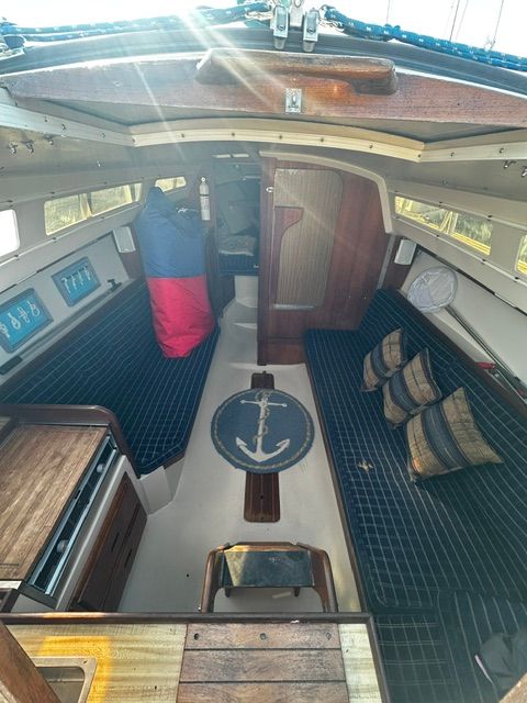 Interior of a 1985 Catalina 27 with blue upholstery and wooden elements.