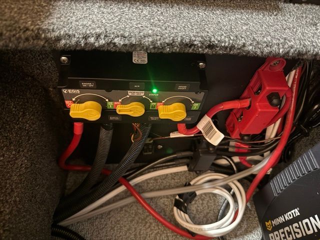 Electrical panel with yellow switches and cables inside a boat.
