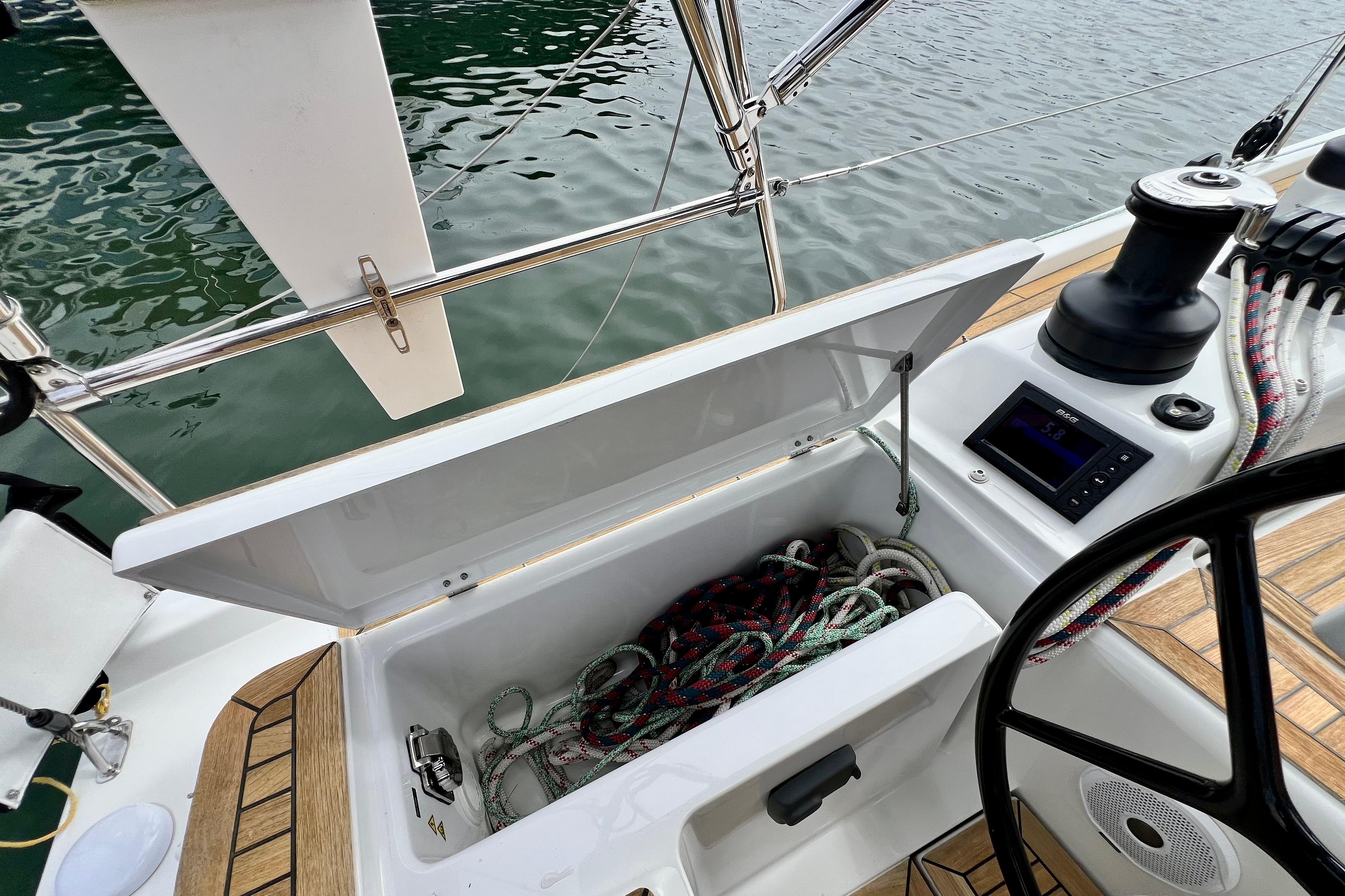 Open storage compartment on 2016 Hanse 455 sailboat, showing ropes and control panel.