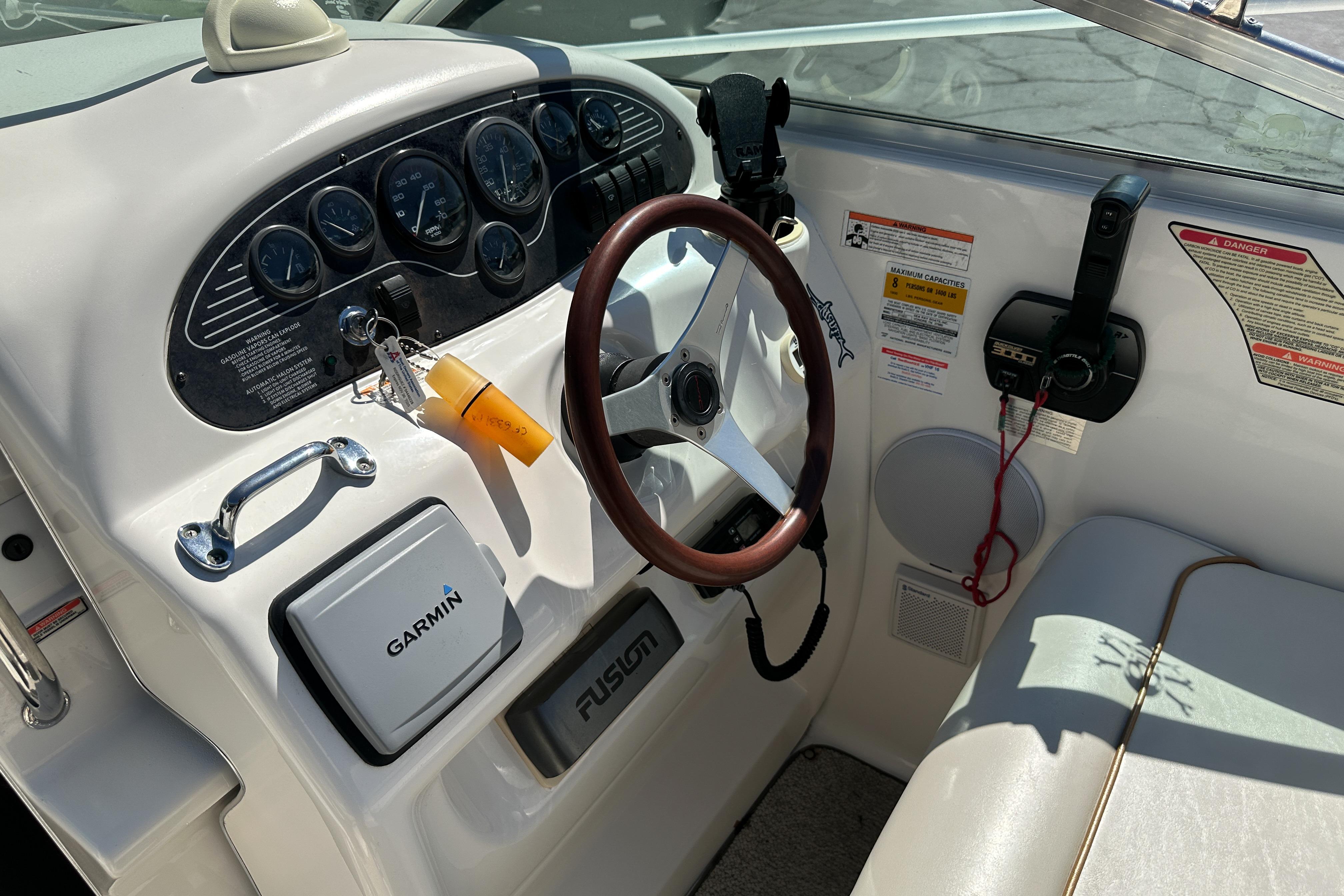 1998 Sea Ray 215 Express Cruiser dashboard with Garmin navigation and wood steering wheel.