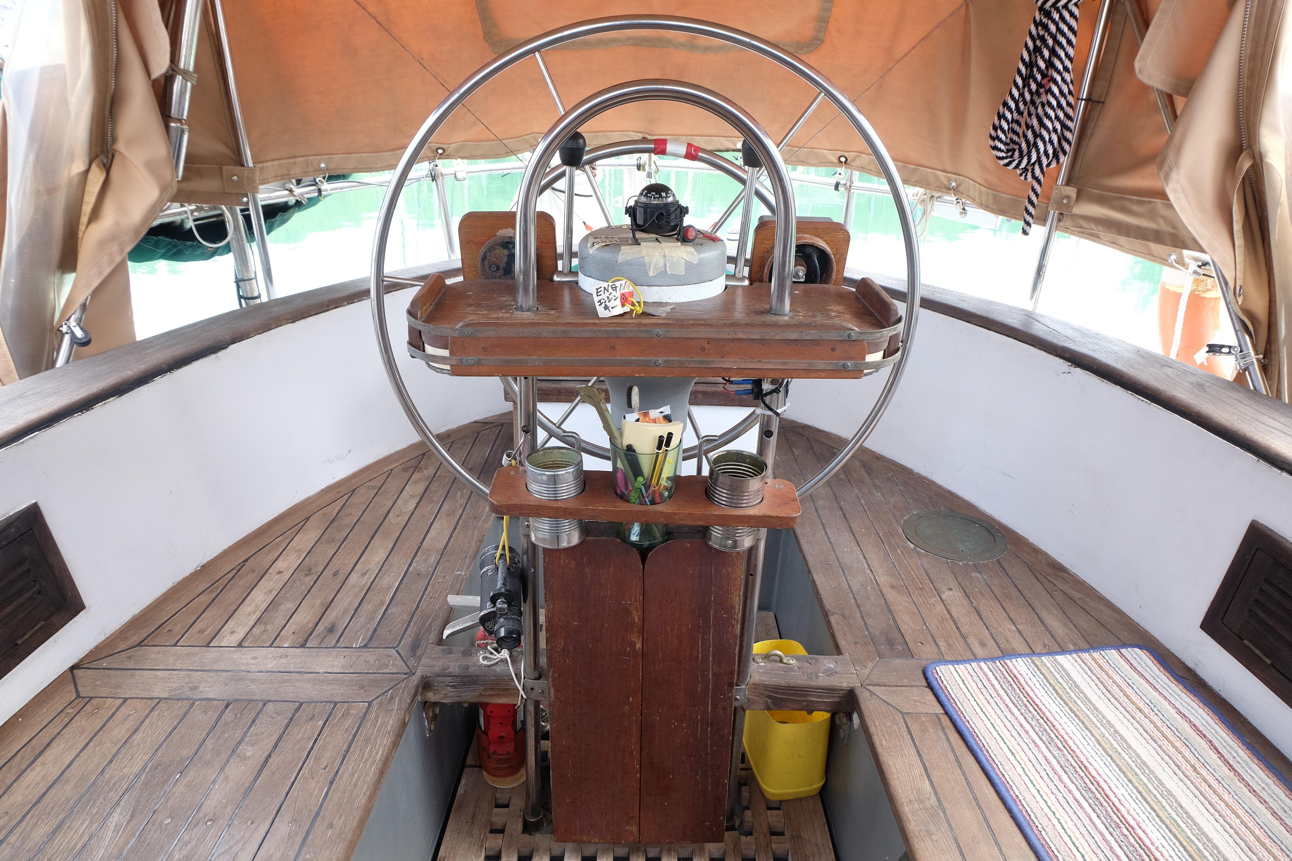 1979 Westwind 35 sailboat cockpit with wooden steering wheel and nautical equipment.