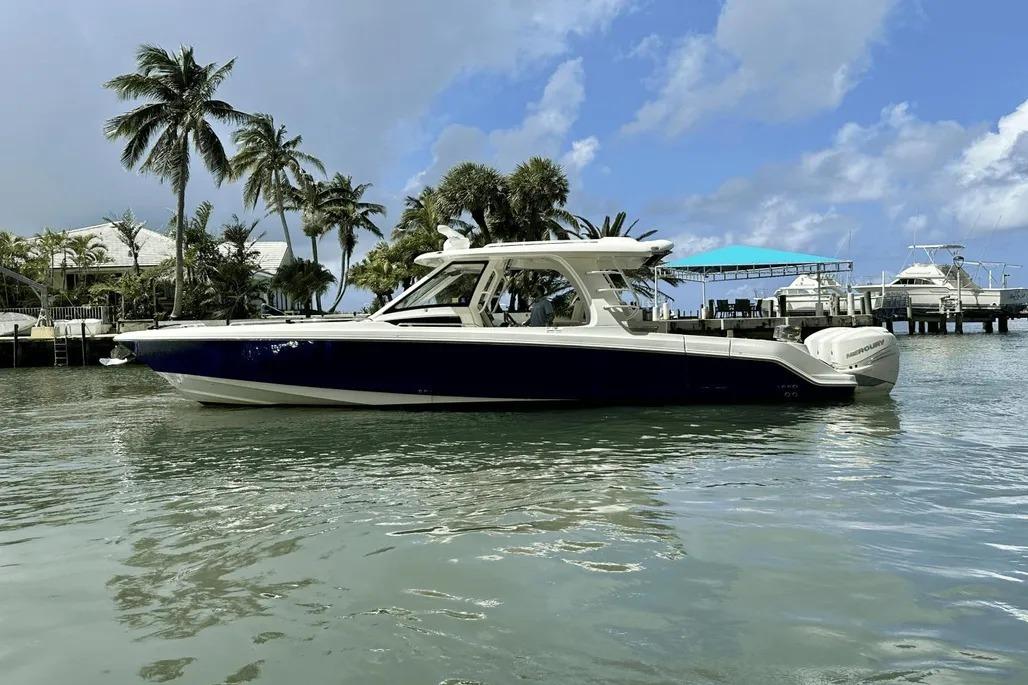2019 Boston Whaler 350 Realm boat on tropical water with palm trees in background.