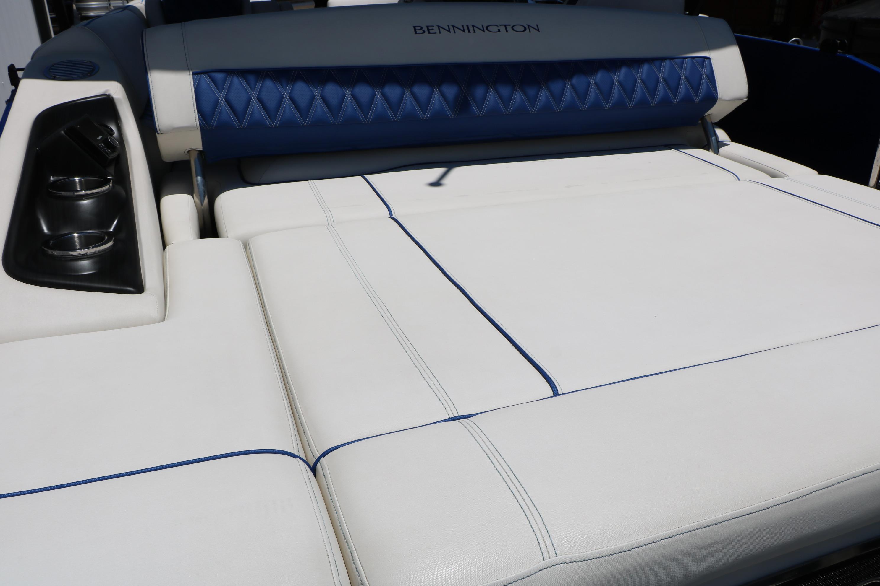 2024 Bennington 23 RX Swingback boat interior with white and blue seating and cup holders.