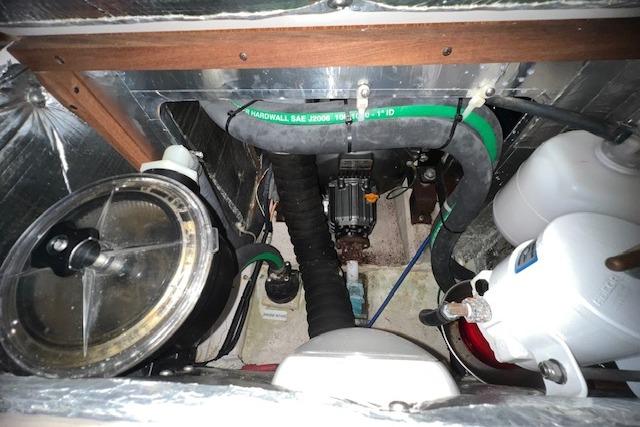 Engine compartment of 2016 Catalina 385 sailboat with visible hoses and components.