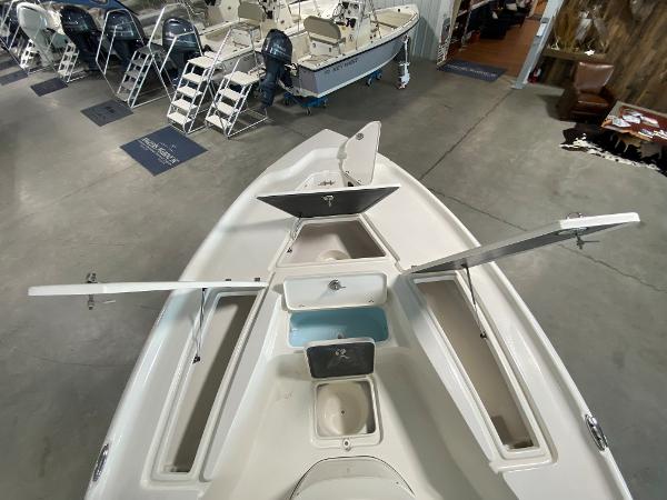 2024 Key West 250 Bay Reef boat with open storage compartments in a showroom.