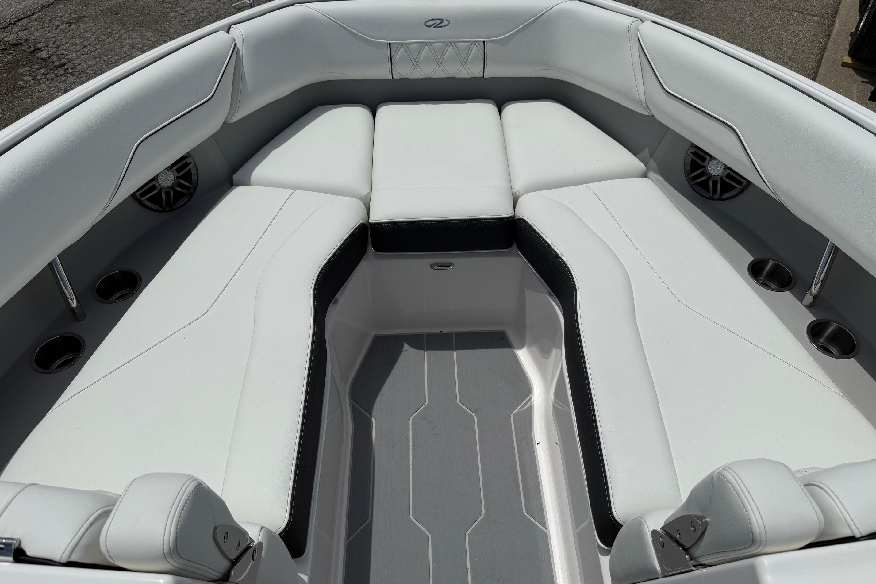2026 Regal LS4 Surf boat interior with white cushioned seating and cup holders.