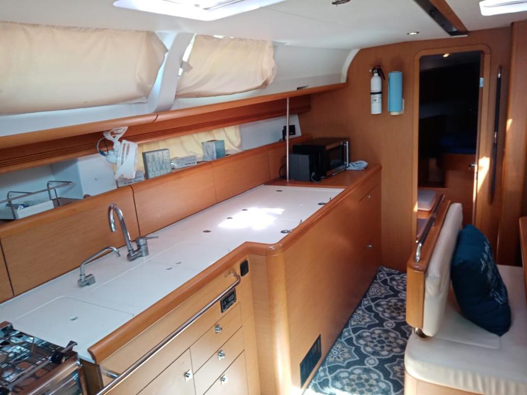 Interior of 2011 Jeanneau Sun Odyssey 45 yacht, featuring modern kitchen and seating area.