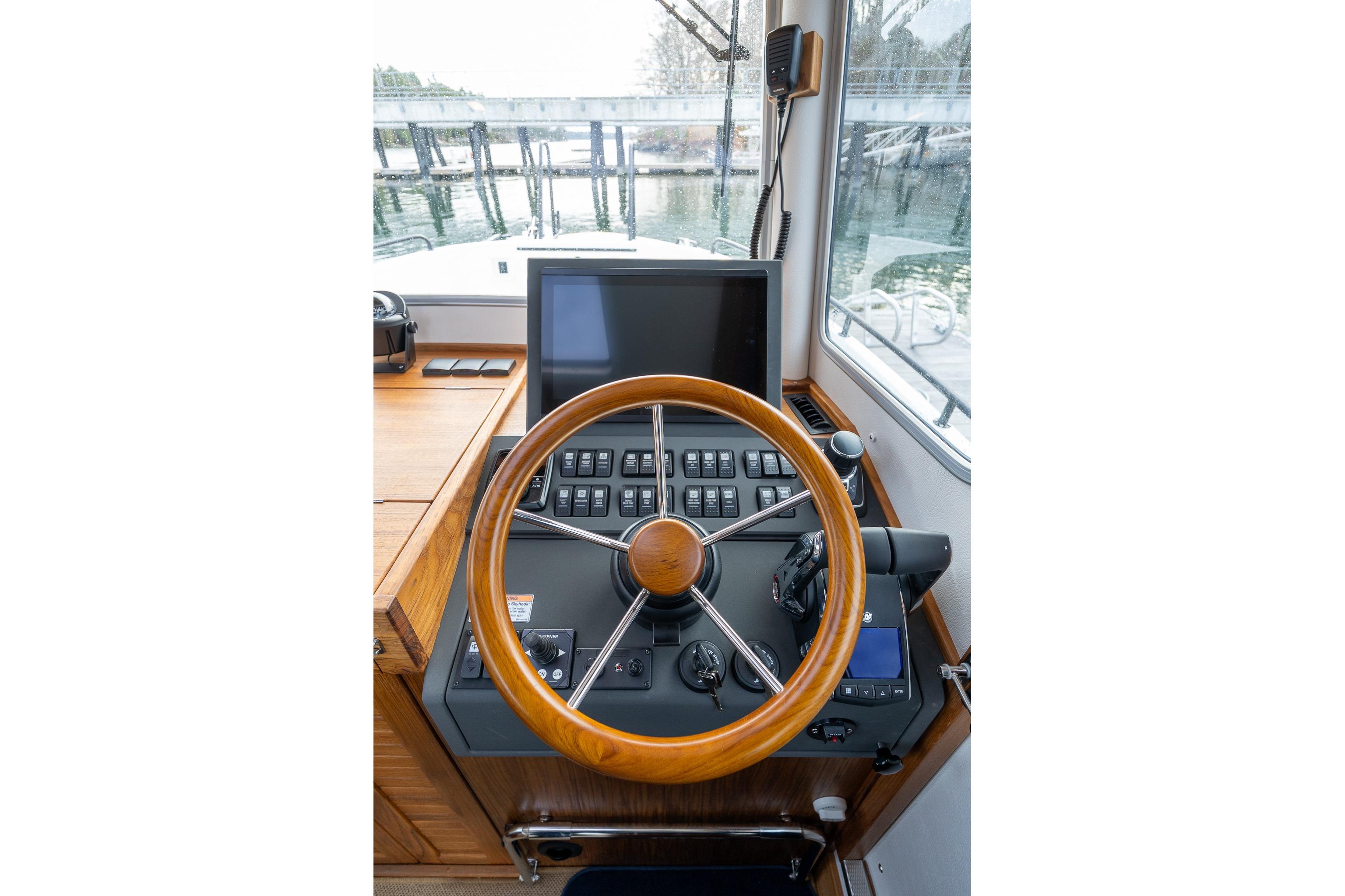 Helm of 2026 Targa 27.2 boat with wooden steering wheel and control panel.