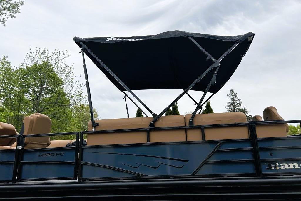 2026 Ranger 220FC boat with canopy and tan seating, set against a cloudy sky.