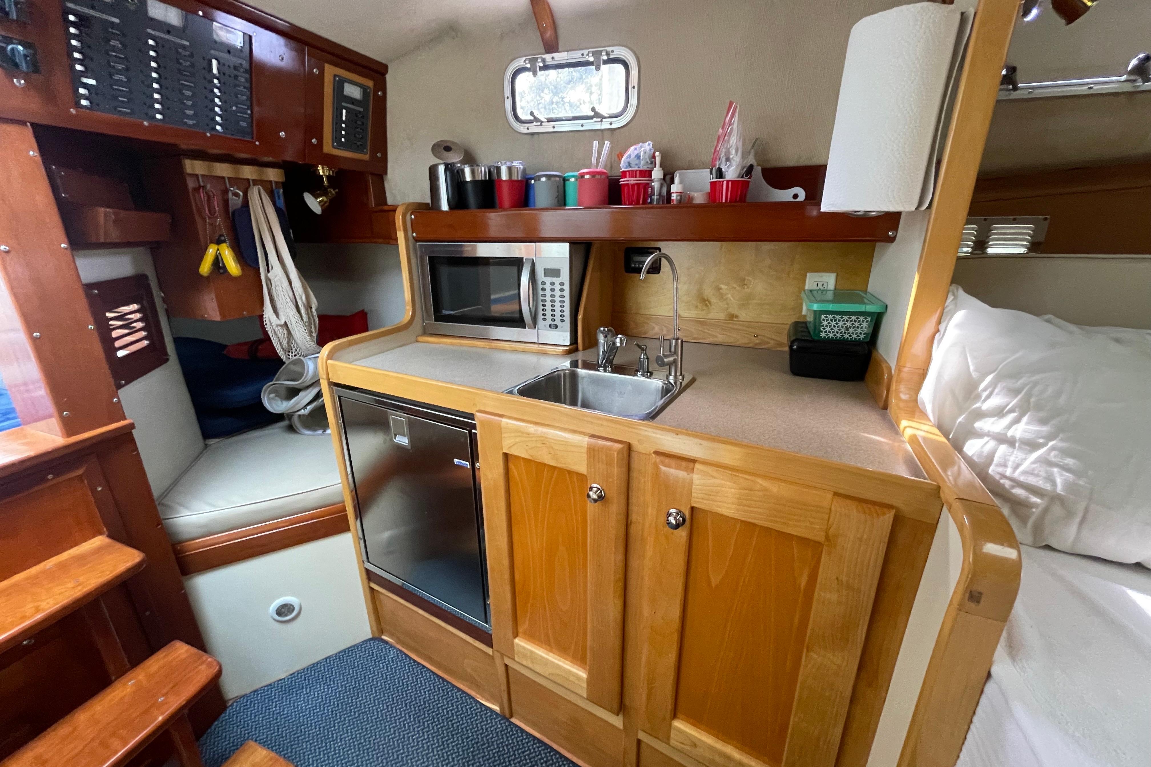 Compact galley kitchen in 2005 Fox Island Thirty Sedan Cruiser with microwave and sink.