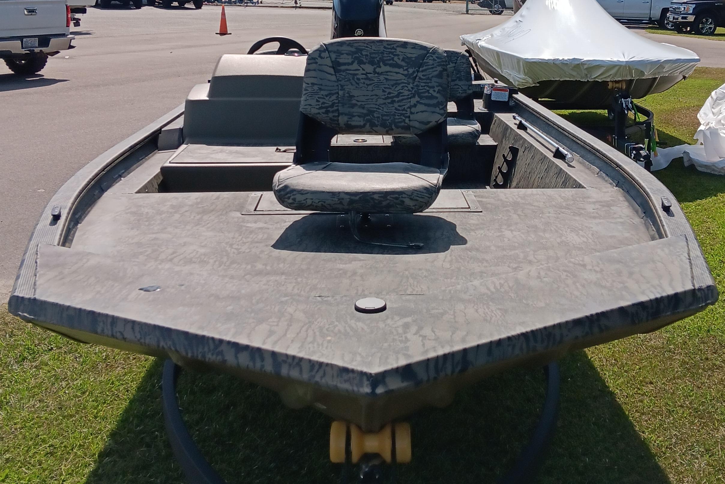 2026 Tracker Grizzly 1754 SC boat with camouflage seating, displayed outdoors.