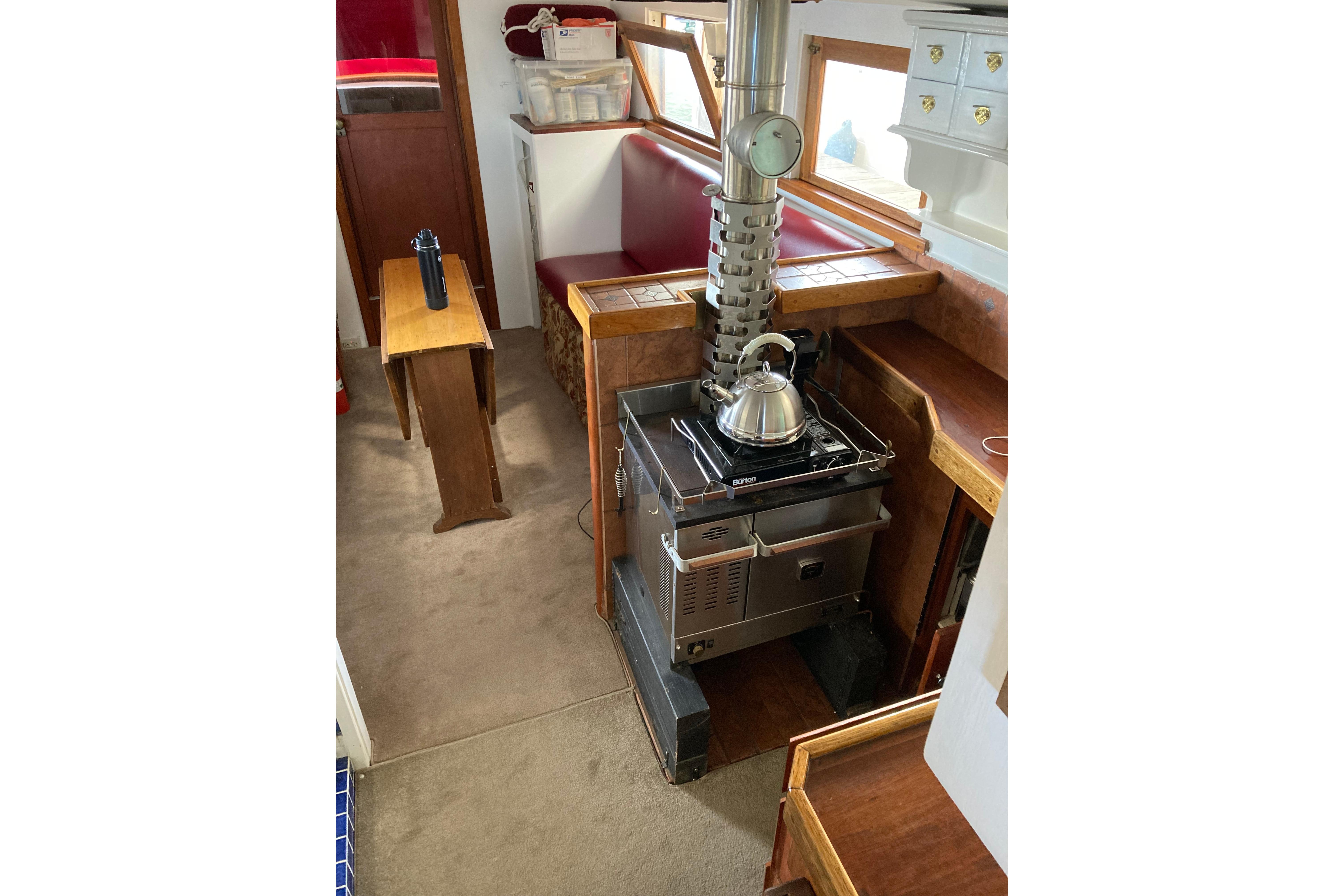 Interior of 1942 Grenfell 42 Custom boat with stove and seating area.