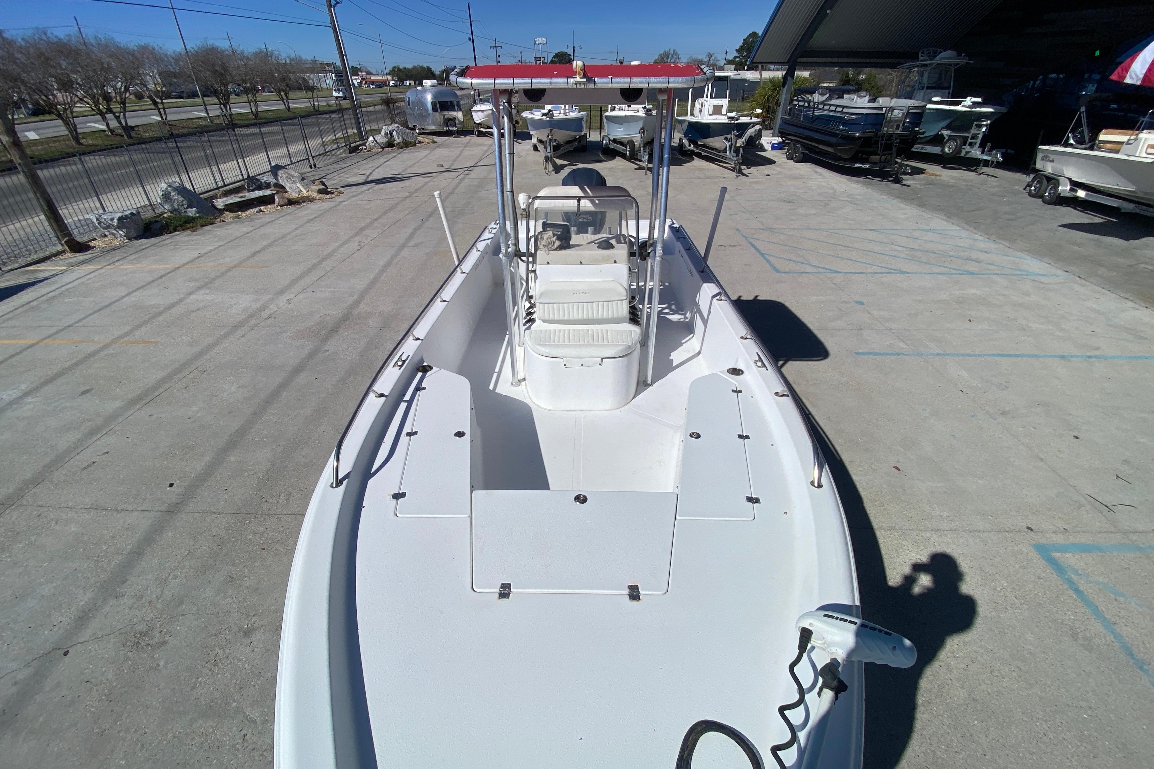 2005 Sea Pro SV2400CC Bay Boat with red canopy, parked in a marina.