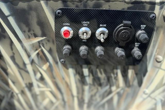 Control panel of 2026 Tracker Grizzly 1654 T Sportsman boat with switches and outlets.