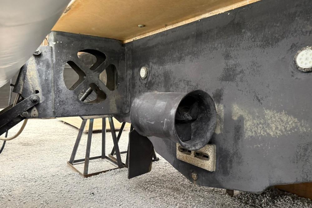 Close-up of a 2007 Marquis 55 LS boat's propeller and hull on a stand.