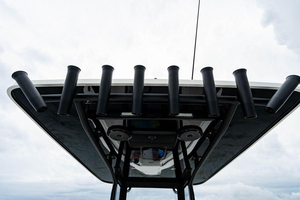 T-top rod holders on 2027 Reef Runner 280 boat against cloudy sky.