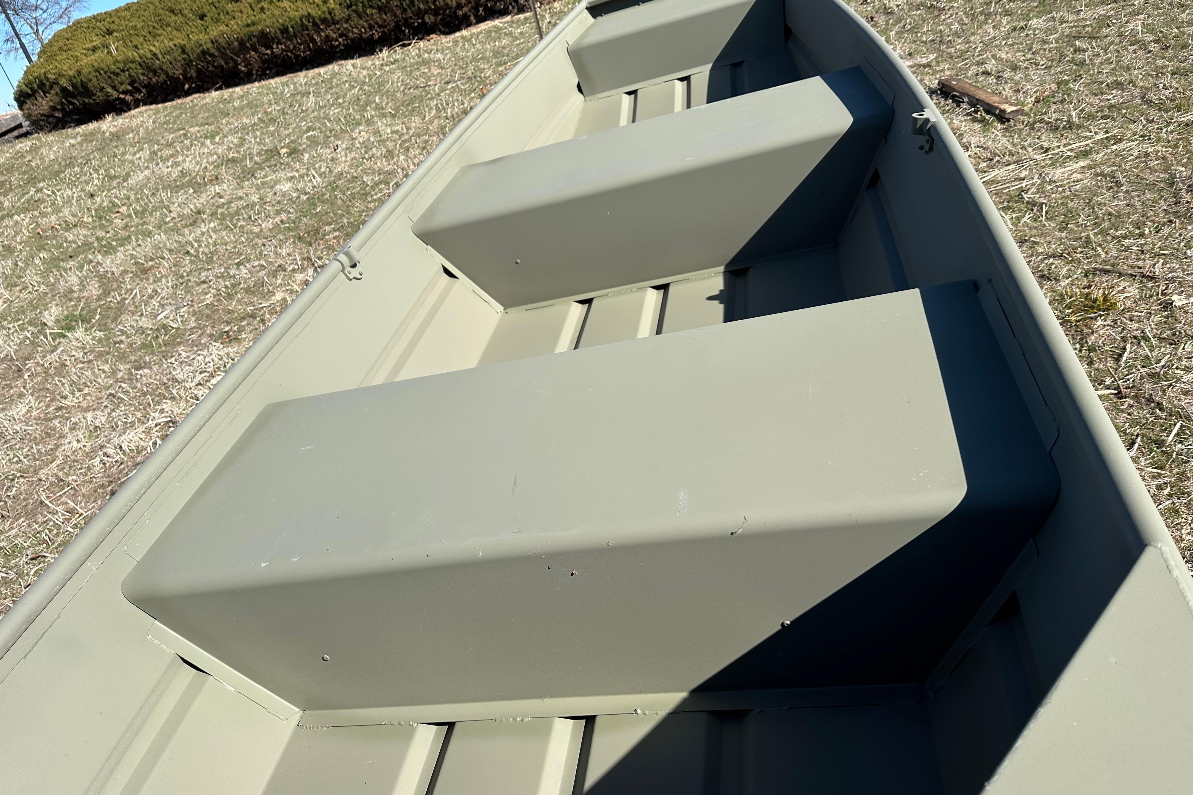 2026 Tracker Grizzly 12 Jon boat interior with bench seats on grassy area.