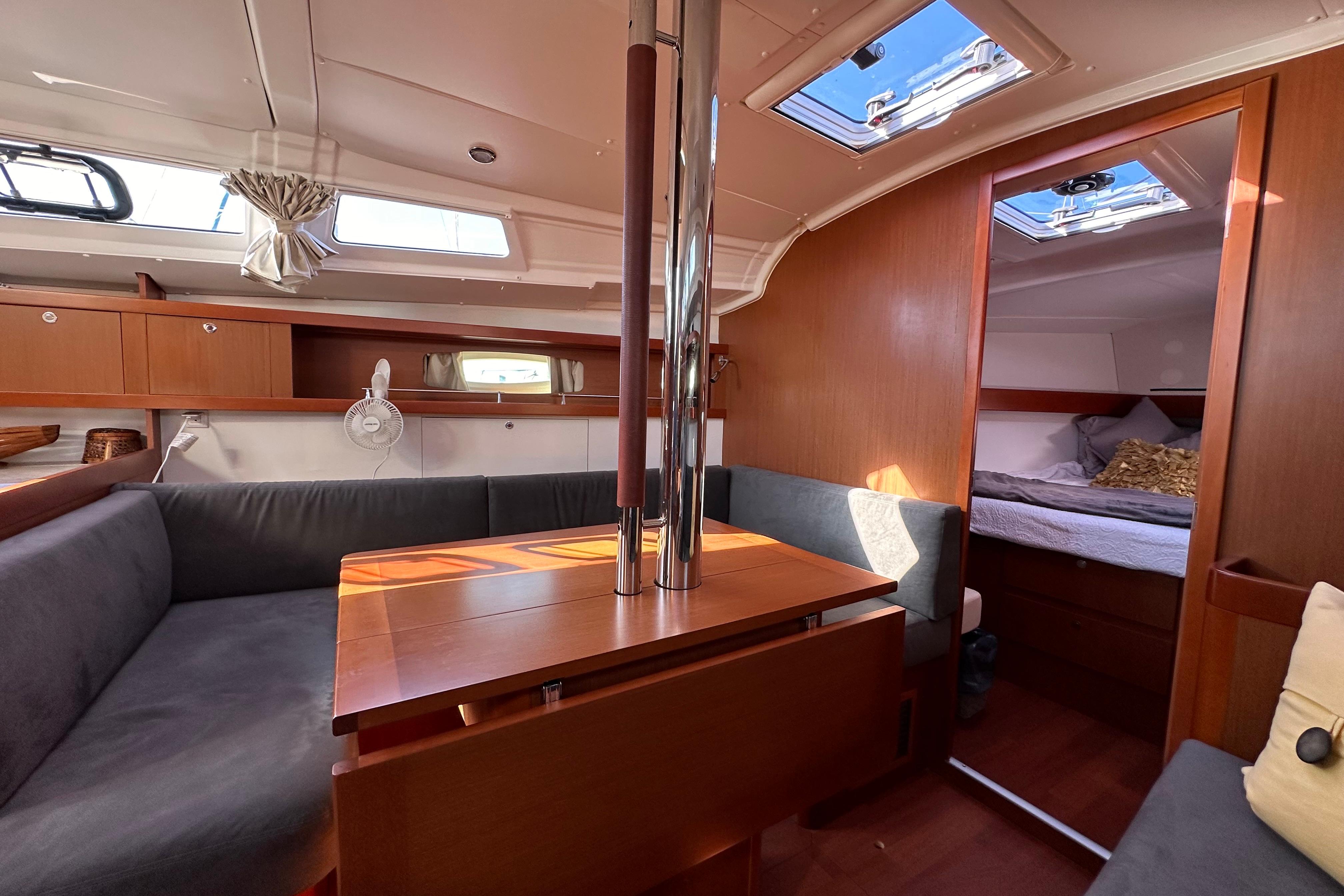 Interior of 2015 Beneteau Oceanis 37 sailboat, featuring cozy seating and a cabin.