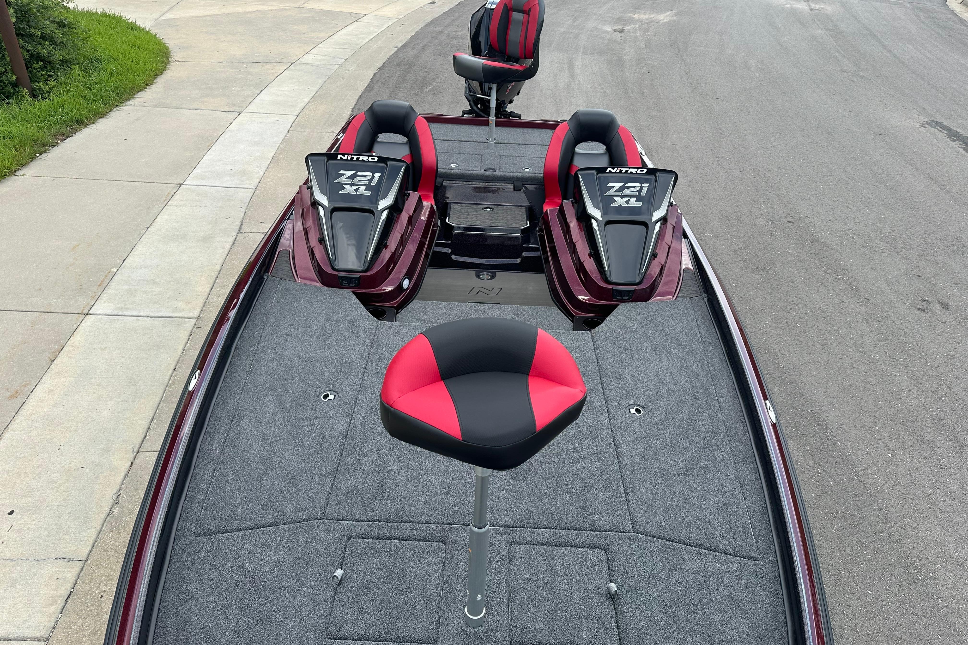 2026 Nitro Z21 XL boat with red and black seating on a paved road.