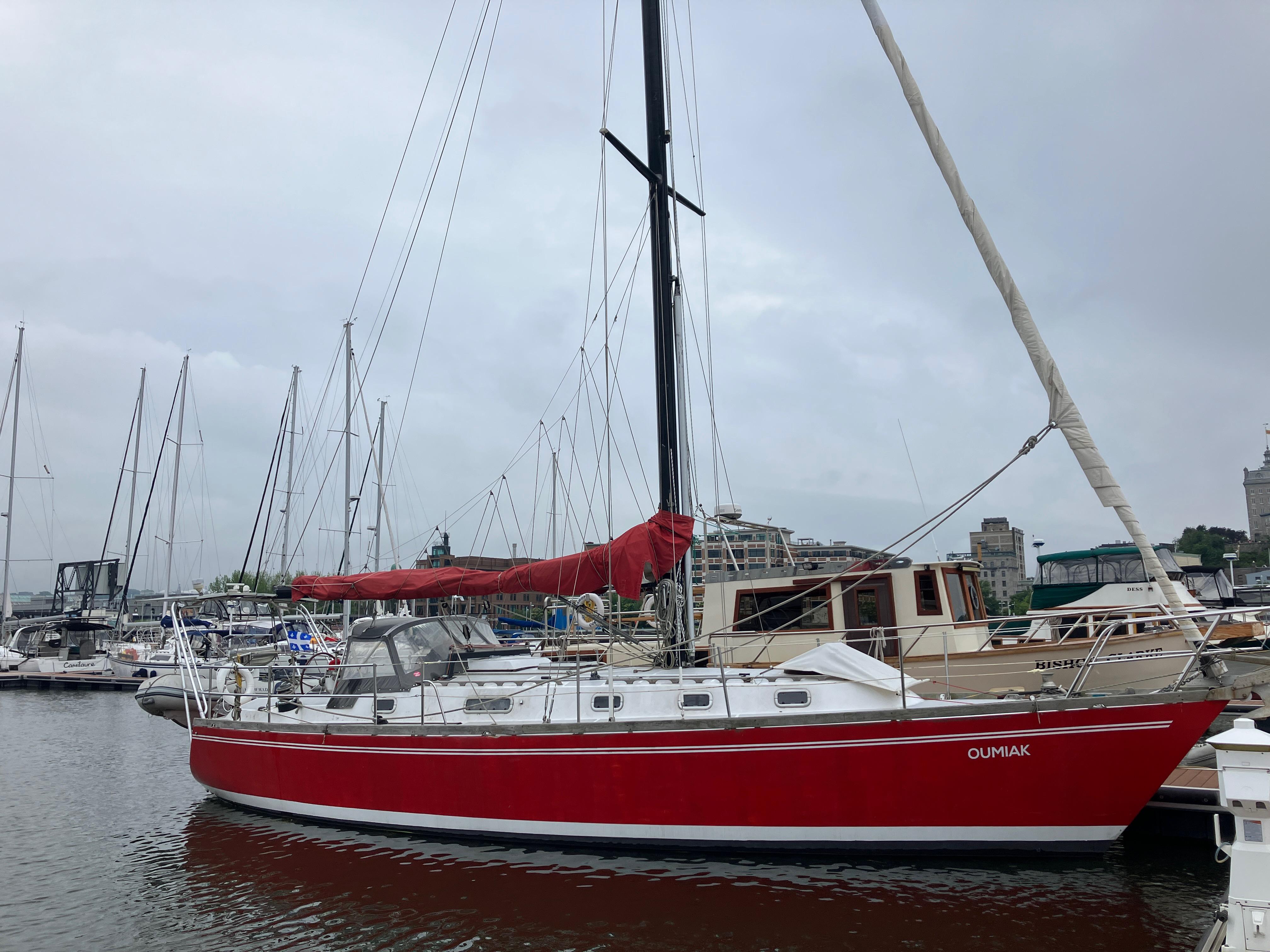 Red MetalCraft Amazon 41 sailboat docked in marina, 1987 model.