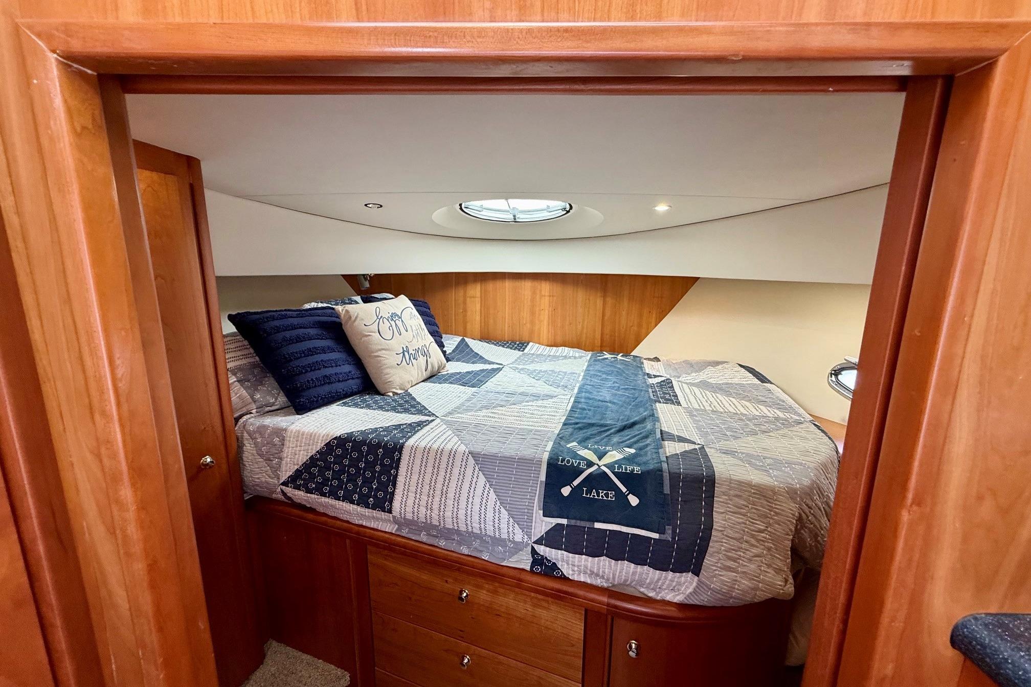 Cozy bedroom in 2004 Silverton 39 Motor Yacht with nautical-themed bedding.
