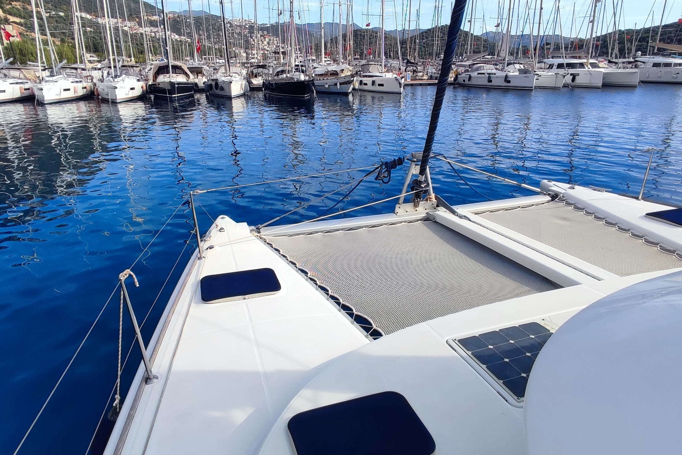 Lagoon 380 S2 catamaran, 2007 model, docked in a marina with clear blue water.