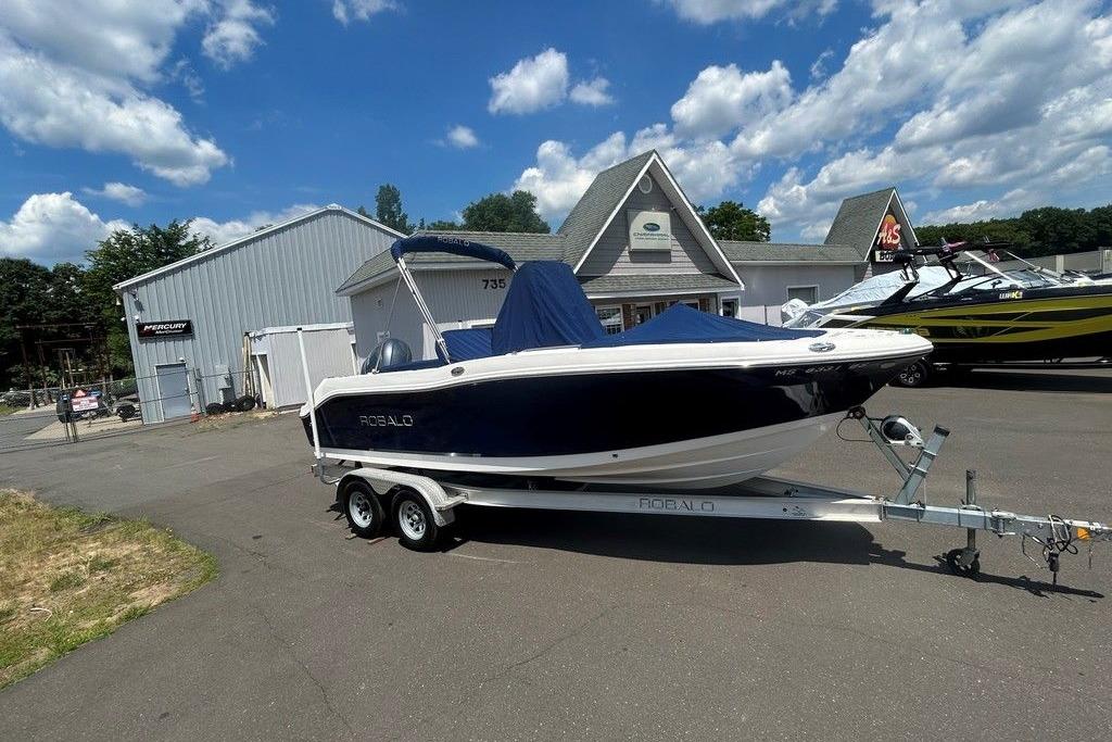 2017 Robalo R200ES boat on trailer, parked outside dealership under blue sky.